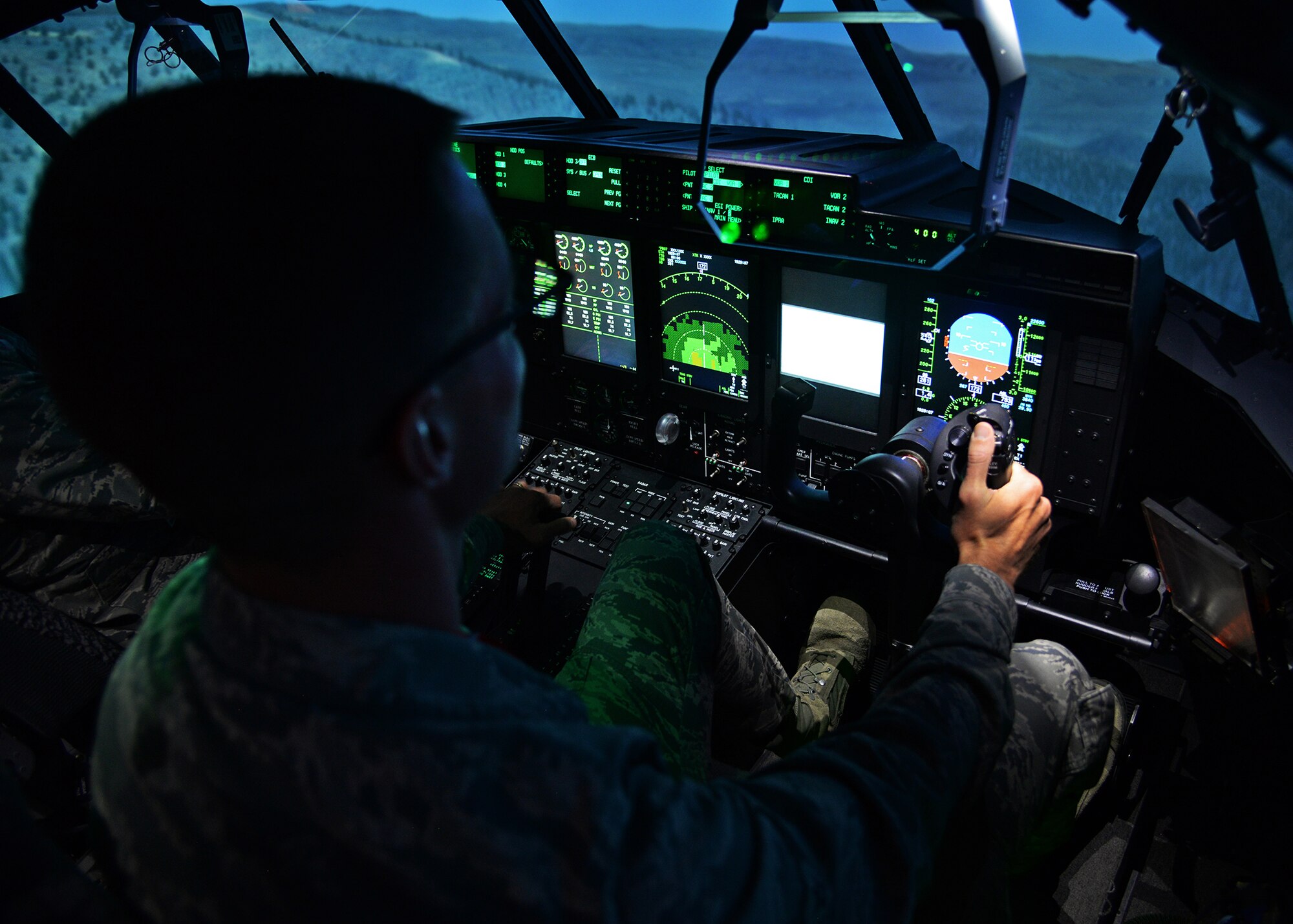 U.S. Air Force Airman 1st Class Nathanael Meyr, 27th Special Operations Wing executive services, sits in the cockpit of an MC-130 J Commando II flight simulator during a tour April 21, 2015 at Cannon Air Force Base, N.M. After receiving instruction from flight instructors, Meyr, as well as other 27th Special Operations Wing Staff Agency Airmen, had the opportunity to take control of the aircraft and simulate a flight plan. (U.S. Air Force photo/Airman 1st Class Chip Slack)