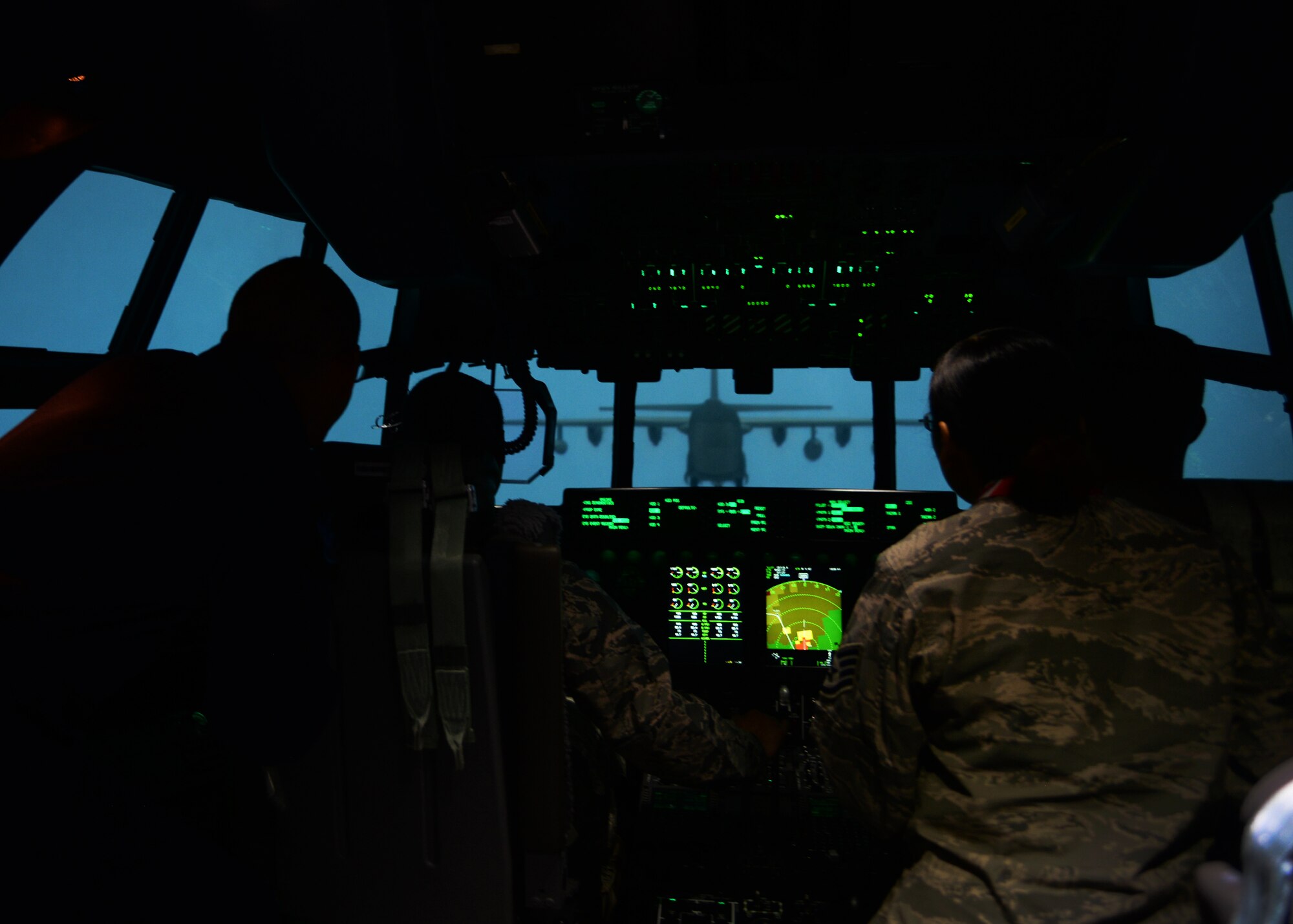 Air Commandos watch as Lockheed Martin flight instructors maneuver around an aircraft during a tour for the 27th Special Operations Wing Staff Agency Airmen April 21, 2015 at Cannon Air Force Base, N.M. The tour afforded Airmen the opportunity to get in the cockpit of an MC-130 J Commando II flight simulator and learn about the substantial training capabilities of the flight simulators. (U.S. Air Force photo/Airman 1st Class Chip Slack)

