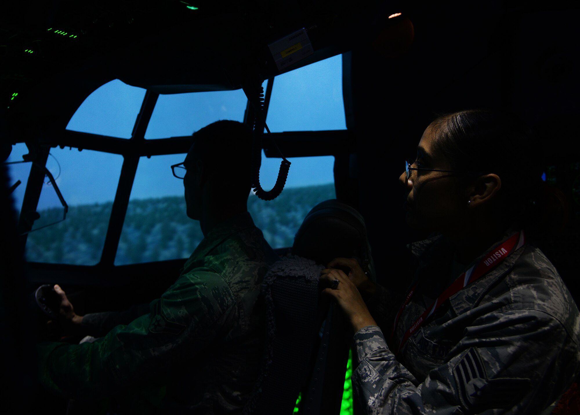 U. S. Air Force Staff Sergeant Leslie Smith, 27th Special Operations Wing NCO in charge of the command section, watches as Airman 1st Class Nathanael Meyr, 27th SOW executive services, takes control of the MC-130 J Commando II flight simulator April 21, 2015 at Cannon Air Force Base, N.M. Both Smith and Meyr were part of a 27th Special Operations Wing Staff Agency tour that highlighted the significant training capabilities of the flight simulators at Cannon. (U.S. Air Force photo/Airman 1st Class Chip Slack)