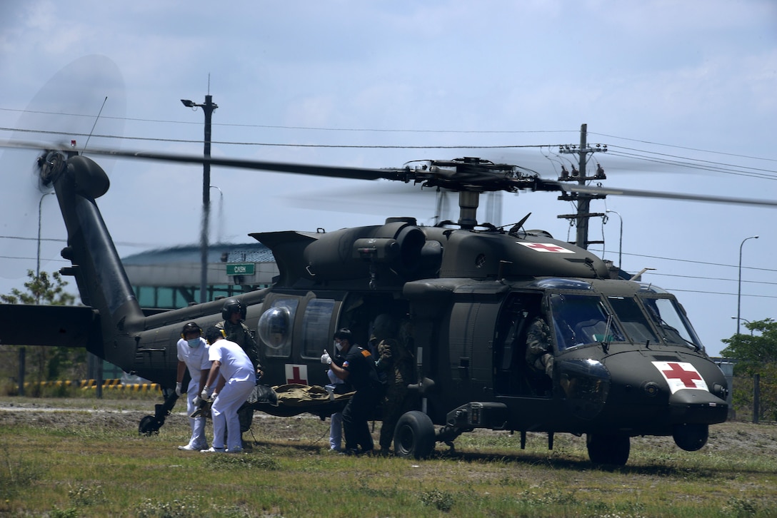 Emergency personnel from Medical City Clark in Pampanga, Philippines, lift a simulated patient on a litter out of a U.S. Army UH-60Q Black Hawk helicopter during Exercise Balikatan 2015, April 18, 2015. Bilateral exercises and security assistance programs with the Philippines ensure that our combined staff planning and disaster relief efforts are more responsive, efficient and effective.