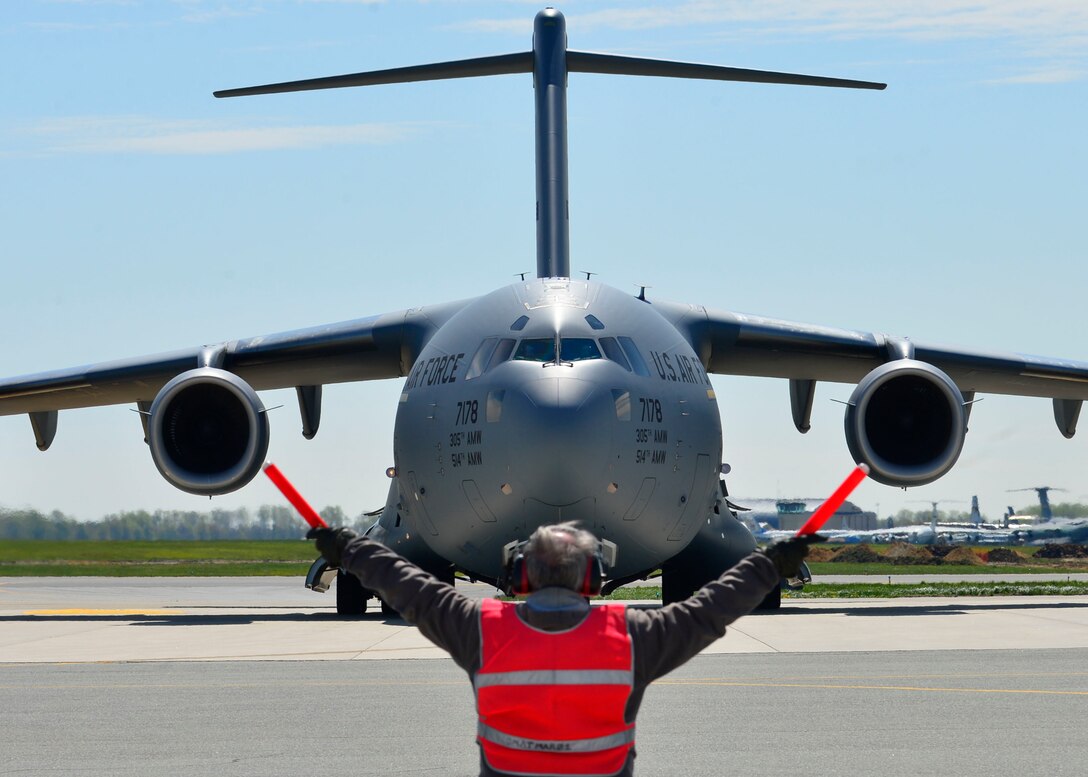 Bill Kennedy marshals a C-17 Globemaster III at Dover Air Force Base, Del., April 26, 2015. The aircraft was loaded with 69 members of the Fairfax County Urban Search and Rescue Team, their supplies and equipment, and six K-9s, to assist Nepal with rescue operations after the country was struck by a 7.8-magnitude earthquake. Kennedy is assigned to the 436th Aircraft Maintenance Squadron transit alert section. (U.S. Air Force photo/Airman 1st Class William Johnson)