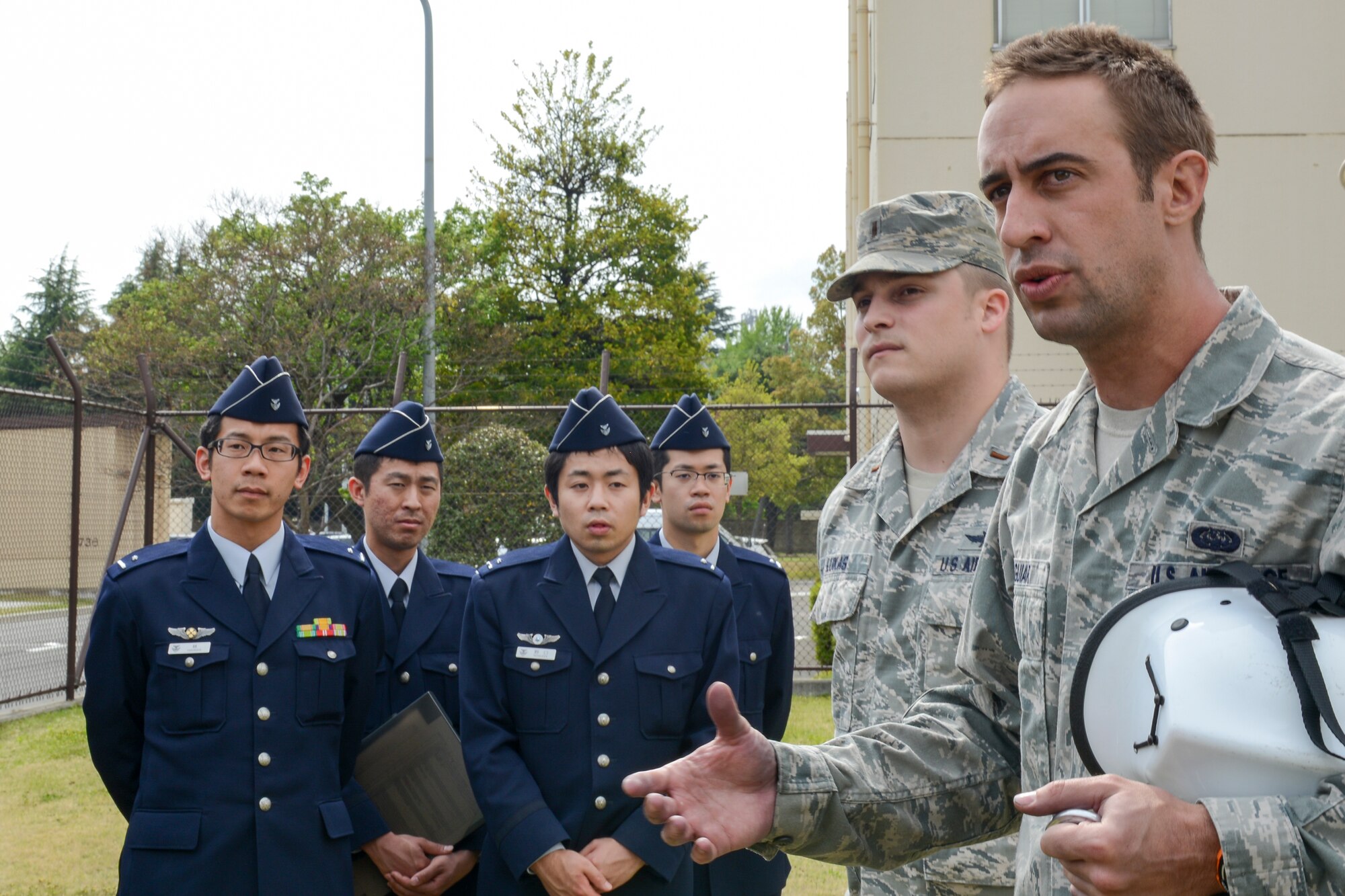 U.S. Air Force Staff Sgt. Zachary Aguiar, center, 374th Communications Squadron cable and antenna systems supervisor, briefs Japan Air Self-Defense Force communications officer students at Yokota Air Base, Japan, April 24, 2015. The JASDF students are from the 4th Technical School, Kumagaya Air Base. (U.S. Air Force photo by Senior Airman Desiree Economides/Released)