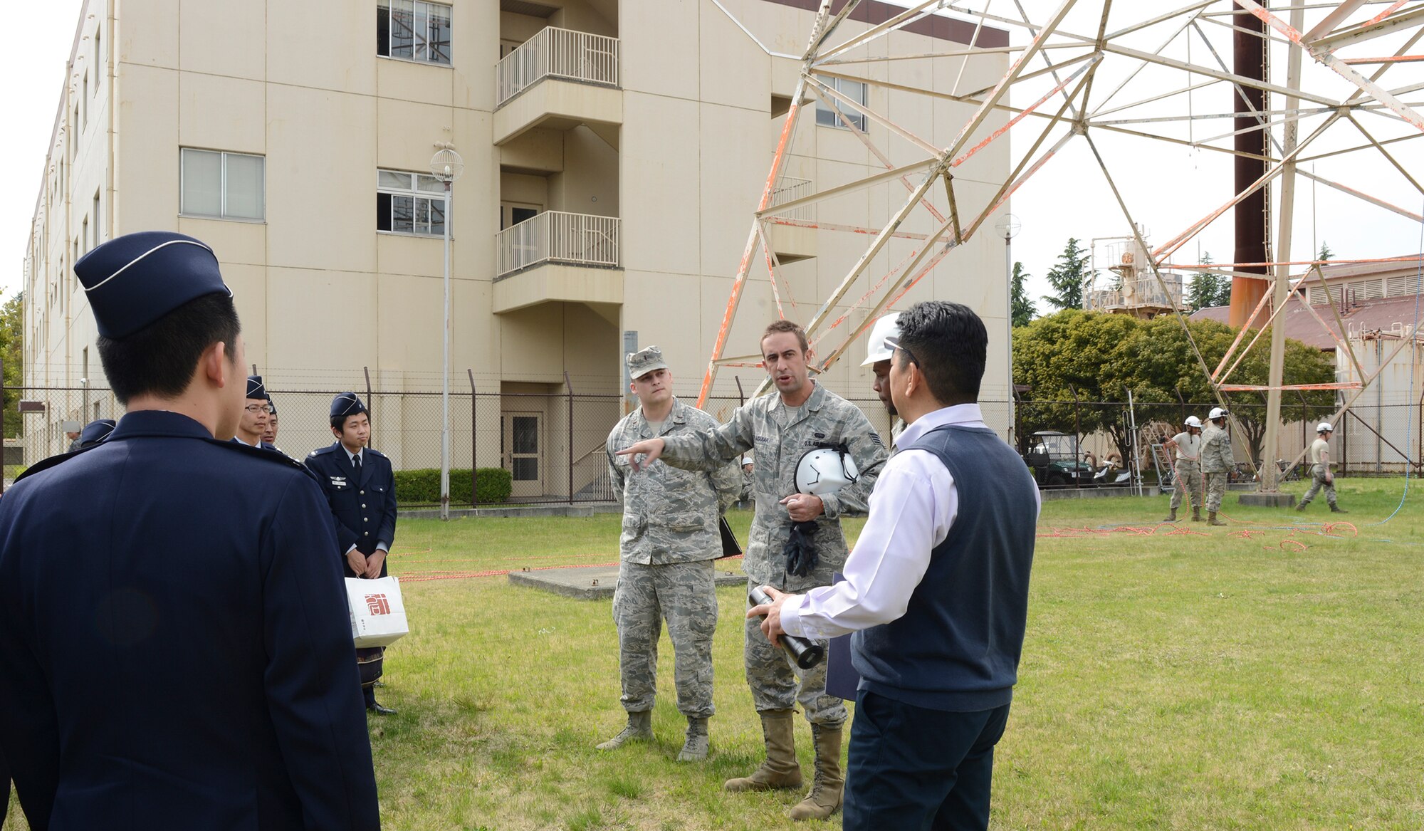 U.S. Air Force Staff Sgt. Zachary Aguiar, center, 374th Communications Squadron cable and antenna systems supervisor, briefs Japan Air Self-Defense Force communications officer students at Yokota Air Base, Japan, April 24, 2015. The JASDF students are from the 4th Technical School, Kumagaya Air Base. (U.S. Air Force photo by Senior Airman Desiree Economides/Released)