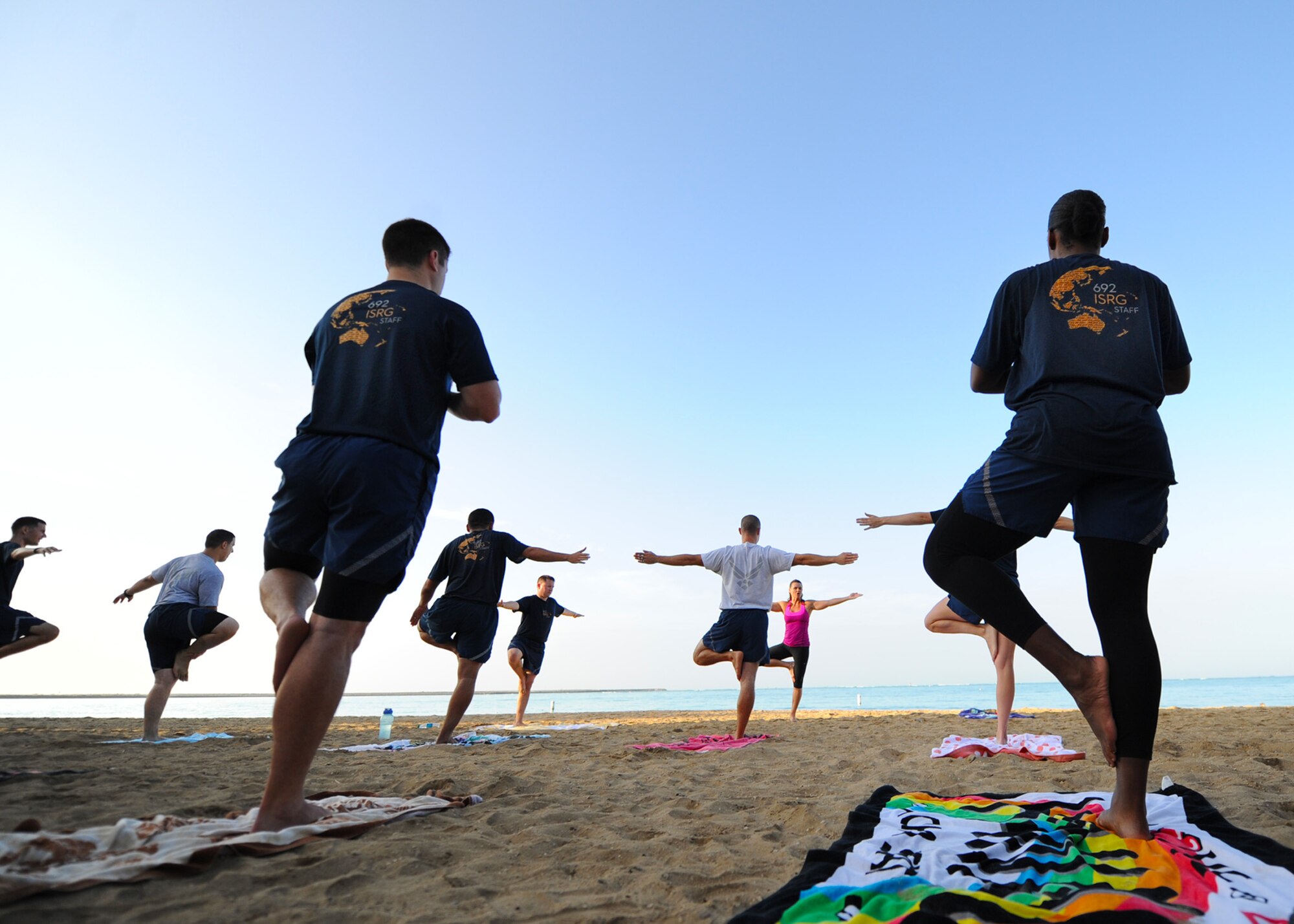 Airmen and their families enjoy a sunrise yoga session, led by local instructor Missy Cornish, as part of Sexual Assault Awareness and Prevention Month at Hickam Beach on Joint Base Pearl Harbor-Hickam, Hawaii, April 24, 2015. The class was just one of the many events held by the Sexual Assault Awareness Prevention Response office to honor the month dedicated to the support of sexual assault victims and their loved ones. (U.S. Air Force photo by 2nd Lt. Kaitlin Daddona/Released)