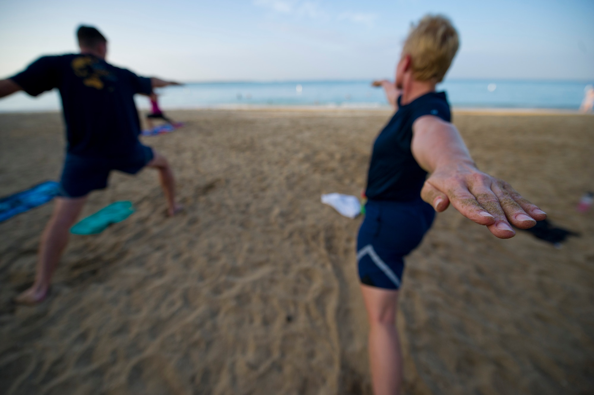 Lt. Col. Regan McClurkin, deputy commander of the 692nd Intelligence, Surveillance and Reconnaissance Group, practices her Warrior pose at the sunrise yoga class held by the Sexual Assault Awareness Prevention Response office at Hickam Beach on Joint Base Pearl Harbor-Hickam, Hawaii, April 24, 2015. The class was just one of the many events held to honor Sexual Assault Awareness and Prevention Month, which is dedicated to the support of sexual assault victims and their loved ones. (U.S. Air Force photo by 2nd Lt. Kaitlin Daddona/Released)