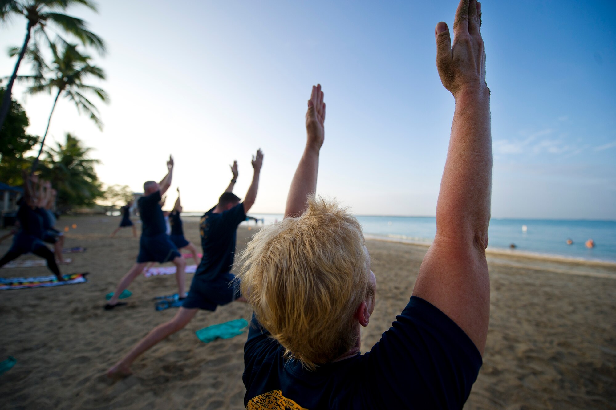 Lt. Col. Regan McClurkin, deputy commander of the 692nd Intelligence, Surveillance and Reconnaissance Group, practices her Warrior pose at the sunrise yoga class held by the Sexual Assault Awareness Prevention Response office at Hickam Beach on Joint Base Pearl Harbor-Hickam, Hawaii, April 24, 2015. The class was just one of the many events held to honor Sexual Assault Awareness and Prevention Month, which is dedicated to the support of sexual assault victims and their loved ones. (U.S. Air Force photo by 2nd Lt. Kaitlin Daddona/Released)