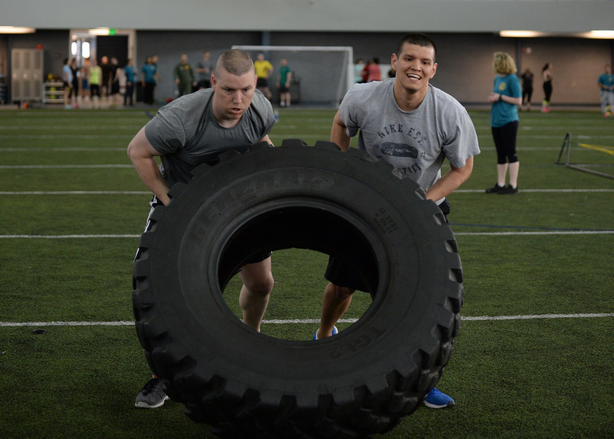 U.S. Air Force Capt. Cameron Maher (left) and Tech. Sgt. David Morin, both from the 354th Security Forces Squadron, flip a tire during the “Tough Enough” competition April 24, 2015, at the Baker Field House on Eielson Air Force Base, Alaska. The “Tough Enough” competition was a series of strength-based exercises to promote sexual assault awareness and prevention while introducing knowledge on the subject. (U.S. Air Force photo by Staff Sgt. Shawn Nickel/Released)