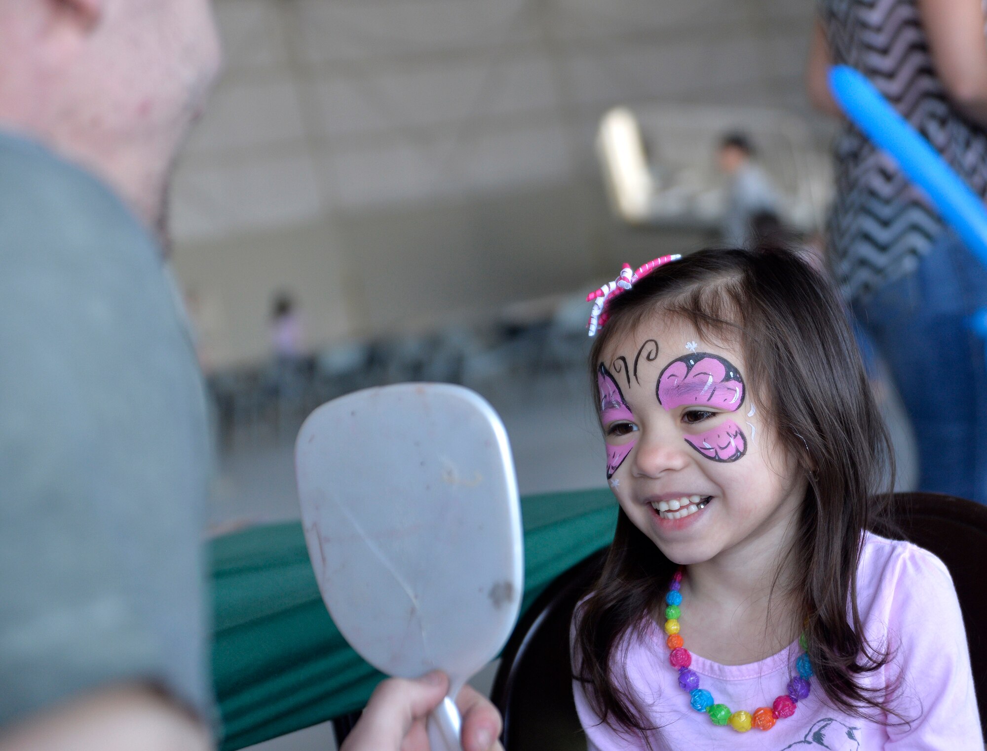 Alison West, five, daughter of Tech. Sgt. Jason West, 432nd Operations Group information systems security officer, smiles after having her face painted  during  the “Take Your Kid to Work Day” event April 23, 2015, at Creech Air Force Base, Nevada. As part of the Department of Defense observance of Month of the Military Child, Creech Airmen paid tribute to these small tykes by honoring them with a “Bring Your Kid to Work Day” event. (U.S. Air Force photo by Airman 1st Class Christian Clausen/Released)
