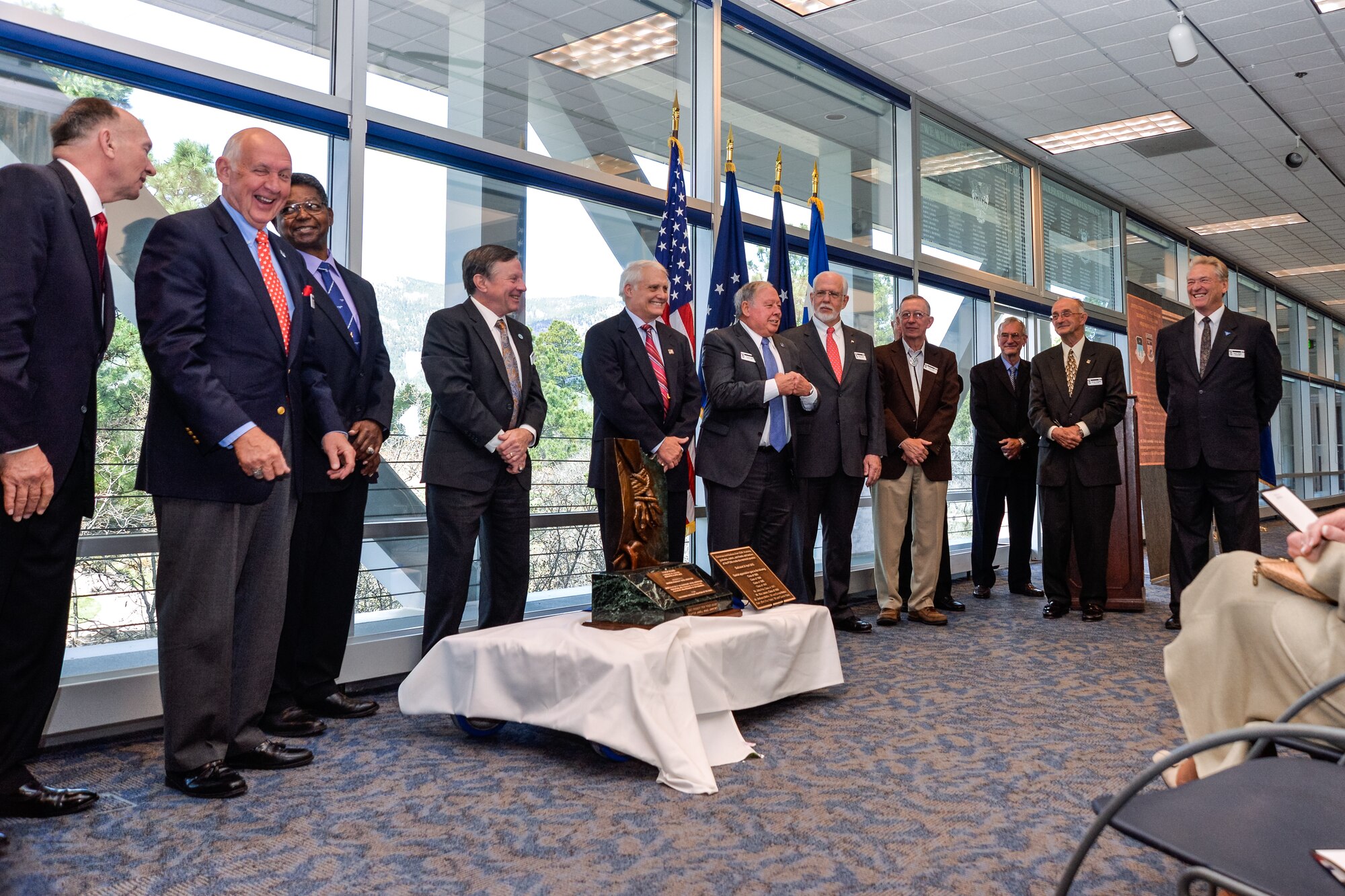 Academy Southeast Asia prisoners of war gather around a sculpture honoring their service and sacrifice during the Vietnam War April 24 at Doolittle Hall. (U.S. Air Force photo/ Liz Copan)