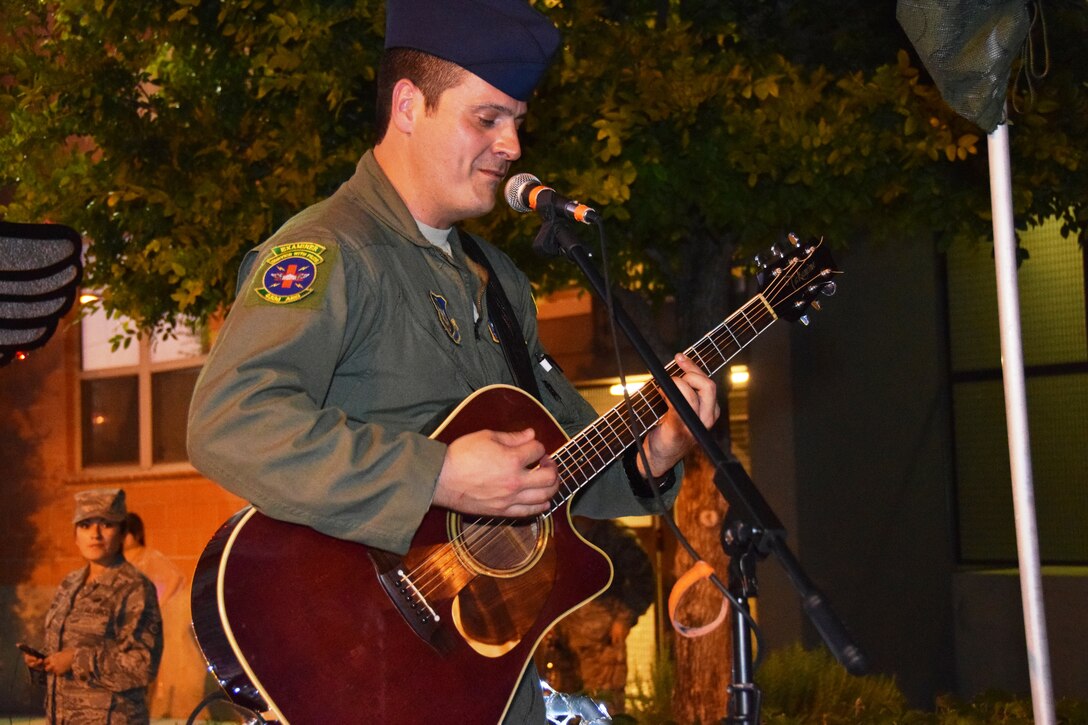 Medical Technician, Tech Sgt. Robert Kirk, with the 433rd Aeromedical Squadron practices singing and playing a Tom Petty song, prior to playing at the Flambeau Parade in San Antonio, while Staff Sgt. Alison Espinoza (left), 433rd Force Support Squadron, personnel specialist, looks on. The parade's theme was “Television: Then and Now,” and according to the Fiesta San Antonio program is “America’s largest illuminated night parade.” Over 600,000 spectators lined the streets of San Antonio on a humid spring evening to see over 200 floats and marching bands perform in the grand finale of Fiesta Week. (U.S. Air Force Photo/ Tech. Sgt. Carlos J. Trevino)

