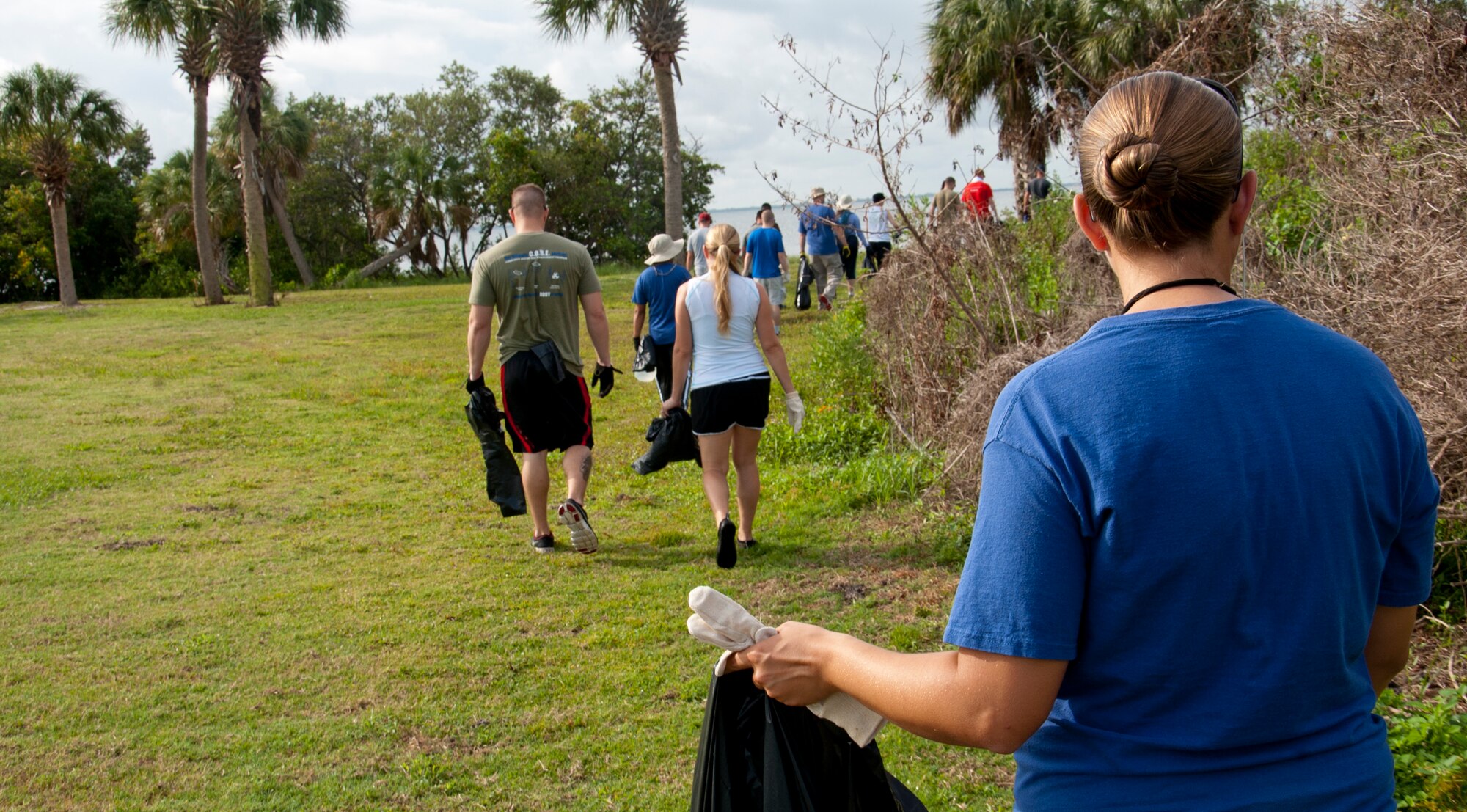 Members from Team MacDill pick up trash along the base shoreline April 24, 2015, at MacDill Air Force Base, Fla. Volunteers spent nearly three hours cleaning up approximately three miles of shoreline from the Thermal Image Radar facility near Eagle Park to the western end of the base beach. (U.S. Air Force photo by Senior Airman Jenay Randolph/Released) 
