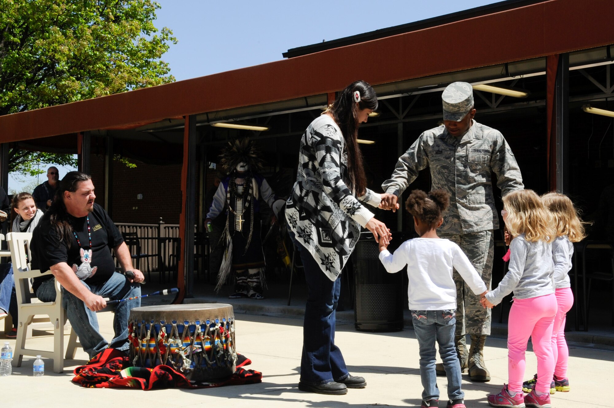 Service members and children dance to music provided by the Mi’kmaq tribe during the National Capital Region Round Up at the Community Commons at Joint Base Andrews, Md., April 24, 2015. More than 1,800 signatures were gathered from service members and family members from JBA and the surrounding community as they signed up for different groups, hobbies, and events. (U.S. Air Force photo by Senior Airman Mariah Haddenham/Released)
