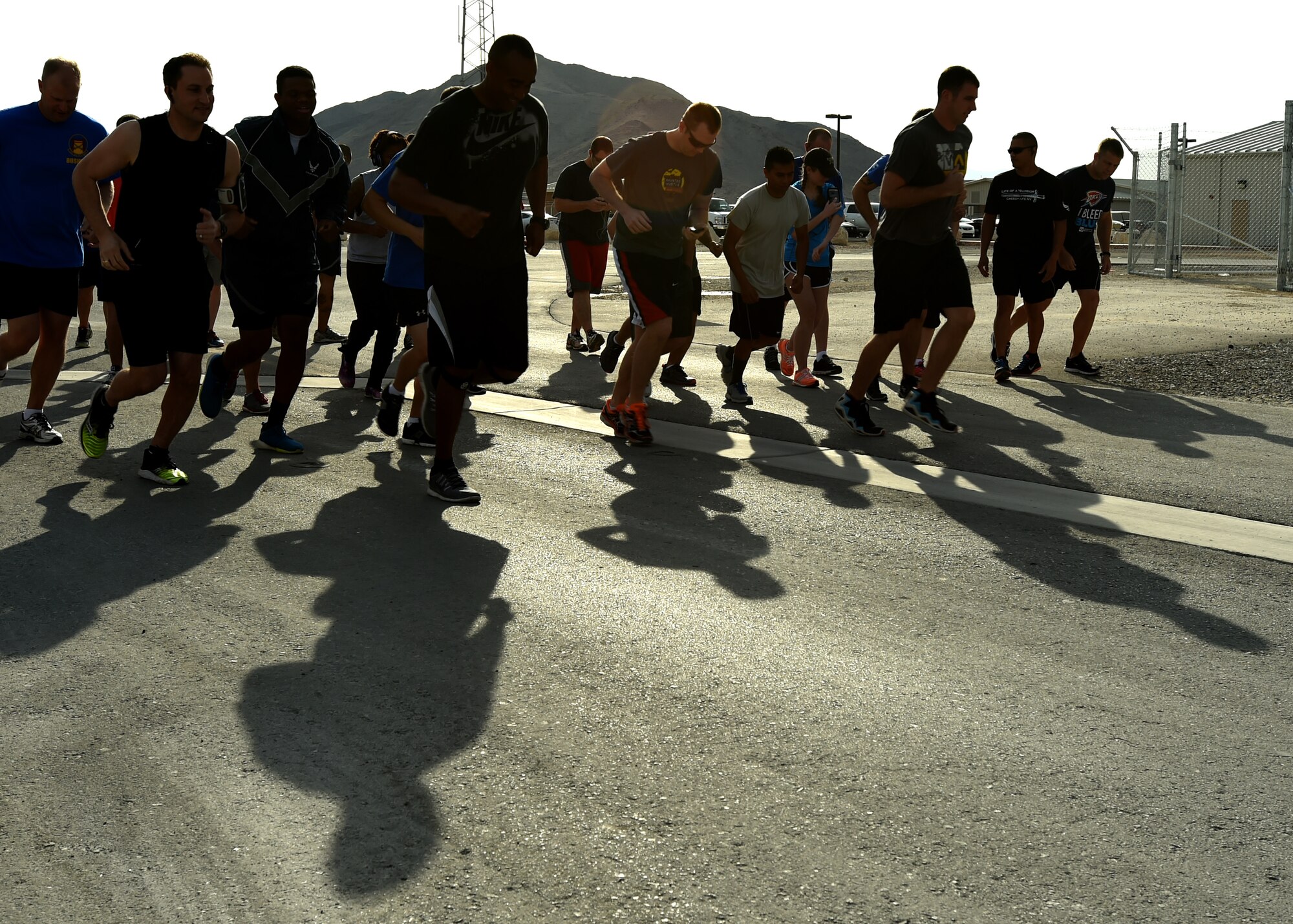 432nd Wing and 799th Air Base Group Airmen burst from the starting line during a 5K run April 24, 2015, at Creech Air Force Base, Nevada. The Sexual Assault Prevention & Response Office, Family Advocacy, and ADAPT offices sponsored the 5K run for several observances held in April. (U.S. Air Force photo by Tech. Sgt. Shad Eidson /Released)