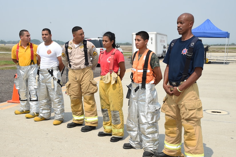 Firefighters representing the six Central American countries which participated in the CENTAM Sharing Mutual Operations Knowledge and Experience exercise, line up in preparation for fire training April 22, 2015 at Soto Cano Air Base, Honduras. The week-long exercise consisted, among other things, of mobile aircraft training, car and helicopter burns, medical instruction, structural burns and HH-60 Blackhawk and CH-47 Chinook familiarization training, all meant to build partnership capacity between the and CENTAM counterparts. (Photo by Martin Chahin)