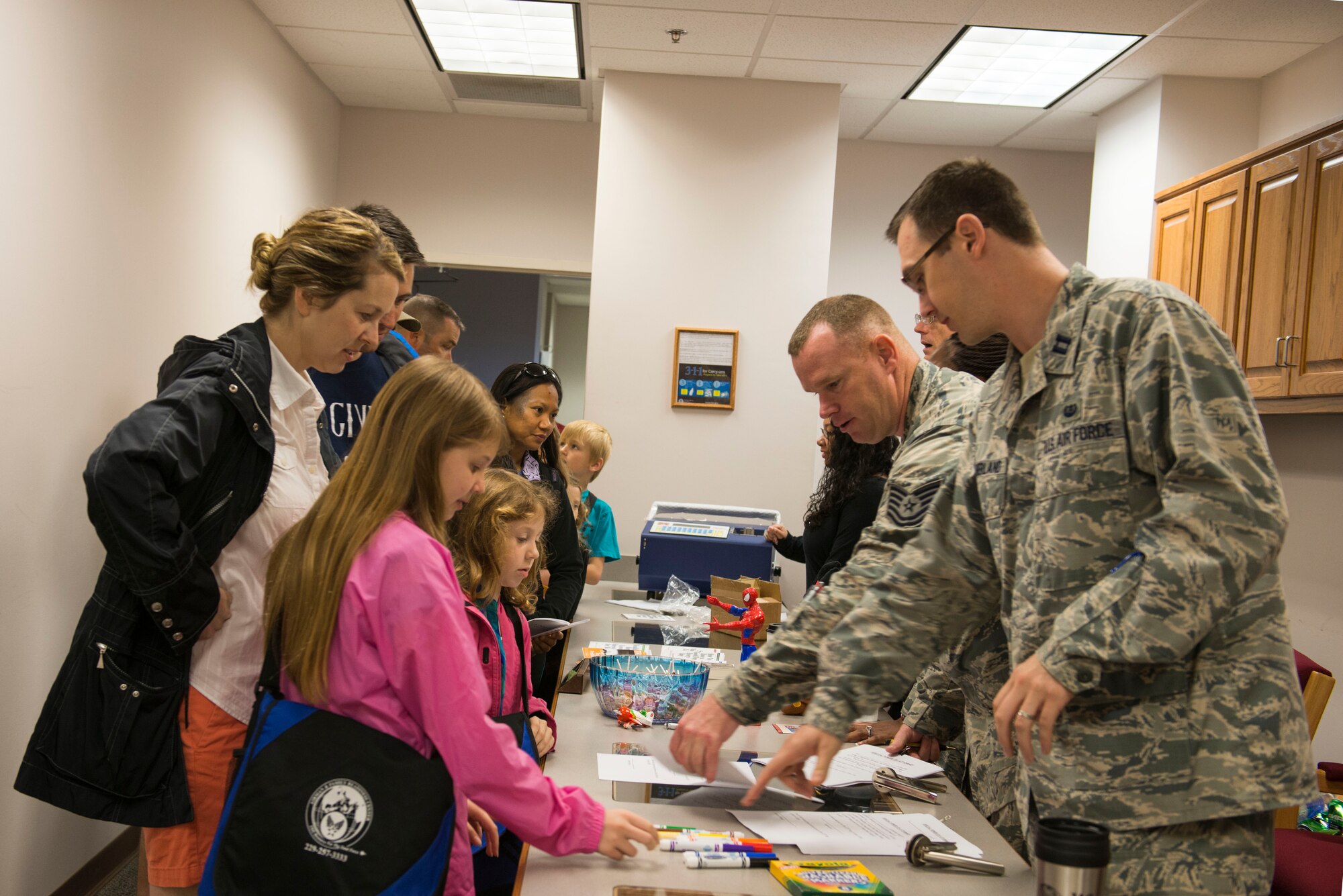 U.S. Air Force Capt. Timothy Sutherland, right, and Tech. Sgt. Terry Beasley, center, 23d Wing Judge Advocate office, give pre-deployment briefings to families during a Kids Deployment Line April 25, 2015, at Moody Air Force Base, Ga. The event gave children new perspectives of what their parents go through before deployments. (U.S. Air Force photo by Airman 1st Class Dillian Bamman/Released)