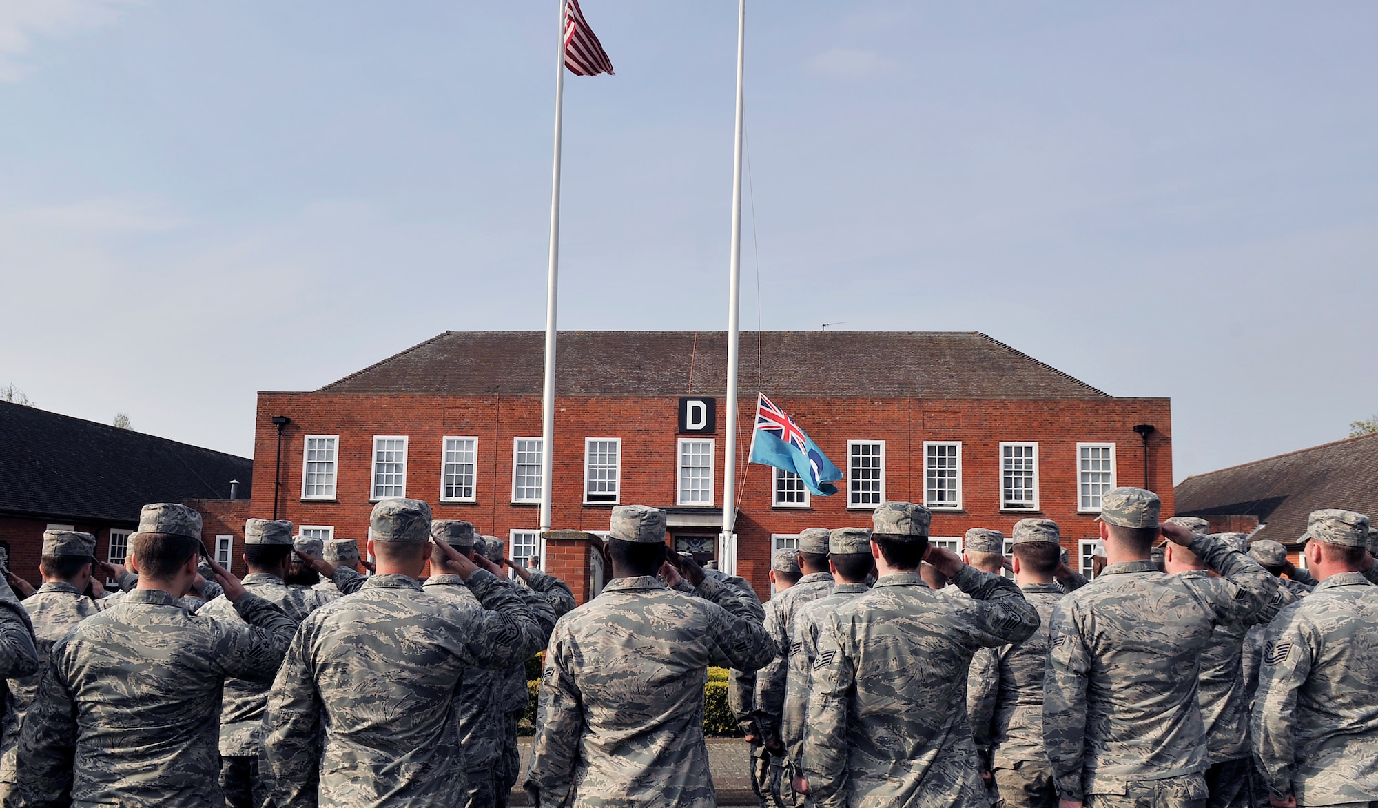 Airmen from the 100th Maintenance Group salute the flags during a monthly retreat ceremony April 24, 2015, at RAF Mildenhall, England. A retreat ceremony, in which the U.S. flag and Royal Air Force ensign are retired, takes place on the last Friday of every month. (U.S. Air Force photo by Airman 1st Class Kyla Gifford/Released)