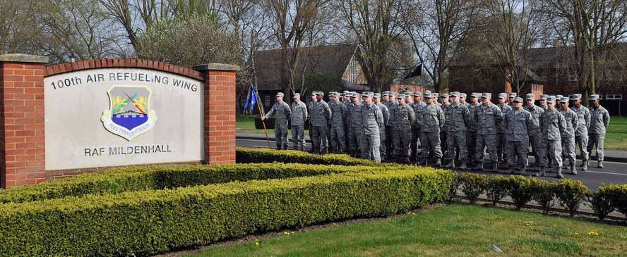 Airmen from the 100th Maintenance Group stand in formation before the start of a monthly retreat ceremony April 24, 2015, at RAF Mildenhall, England. Retreat is a ceremony symbolizing the end of the duty day as well as paying respect to the flags. (U.S. Air Force photo by Airman 1st Class Kyla Gifford/Released)