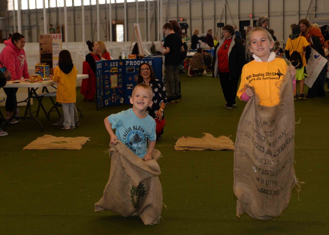 Mason, Son of Nicole and Staff Sgt. Joseph Rammacher, and Raegan, daughter of Master Sgt. Jeffery and Christy Dashner, participate in a sack race at Ellsworth Air Force Base, S.D., April 18, 2015. In celebration of Month of the Military Child, an event held for Ellsworth children at the Pride Hangar featured several activities to include a deployment line, party inflatables, military working dog demonstrations and a rock climbing wall to recognize the contributions of military children while educating them on various aspects of military service. (U.S. Air Force photo by Airman 1st Class Rebecca Imwalle/Released) 