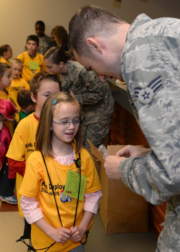 Maylen, daughter of Master Sgt. Steven Henry and Tech. Sgt. Nicole Henry, visits with Senior Airman Erik Perthel, 28th Medical Operations Squadron public health technician, during the Kids Deploy 2015 at Ellsworth Air Force Base, S.D., April 18, 2015. As a part of the Month of the Military Child, this event provided an opportunity for nearly 100 children to experience the deployment process as they walked through the deployment line where they met members from the Chaplain Corps, Finance, and the Medical Group. (U.S. Air Force photo by Airman 1st Class Rebecca Imwalle/Released)