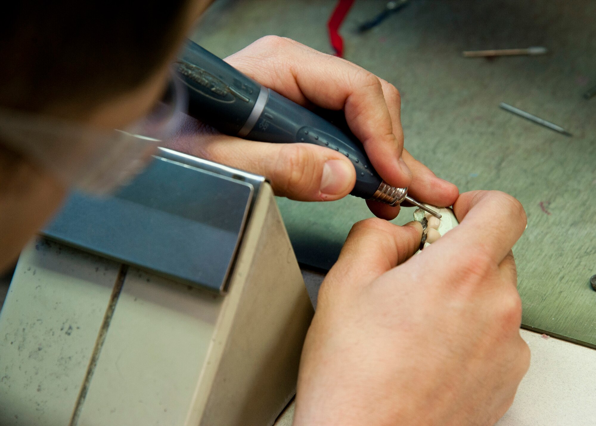 PETERSON AIR FORCE BASE, Colo. – Senior Airman Jonathon Stambaugh, 21st Dental Squadron dental lab technician, creates porcelain teeth at the Area Dental Lab, April 8, 2015. The ADL is one of three Department of Defense labs that provide fixed dental works along with removable dental works and services Department of Defense bases around the world. The other two ADLs are in Ramstein AB, Germany, and Kadena AB, Japan. (U.S. Air Force photo by Senior Airman Tiffany DeNault)