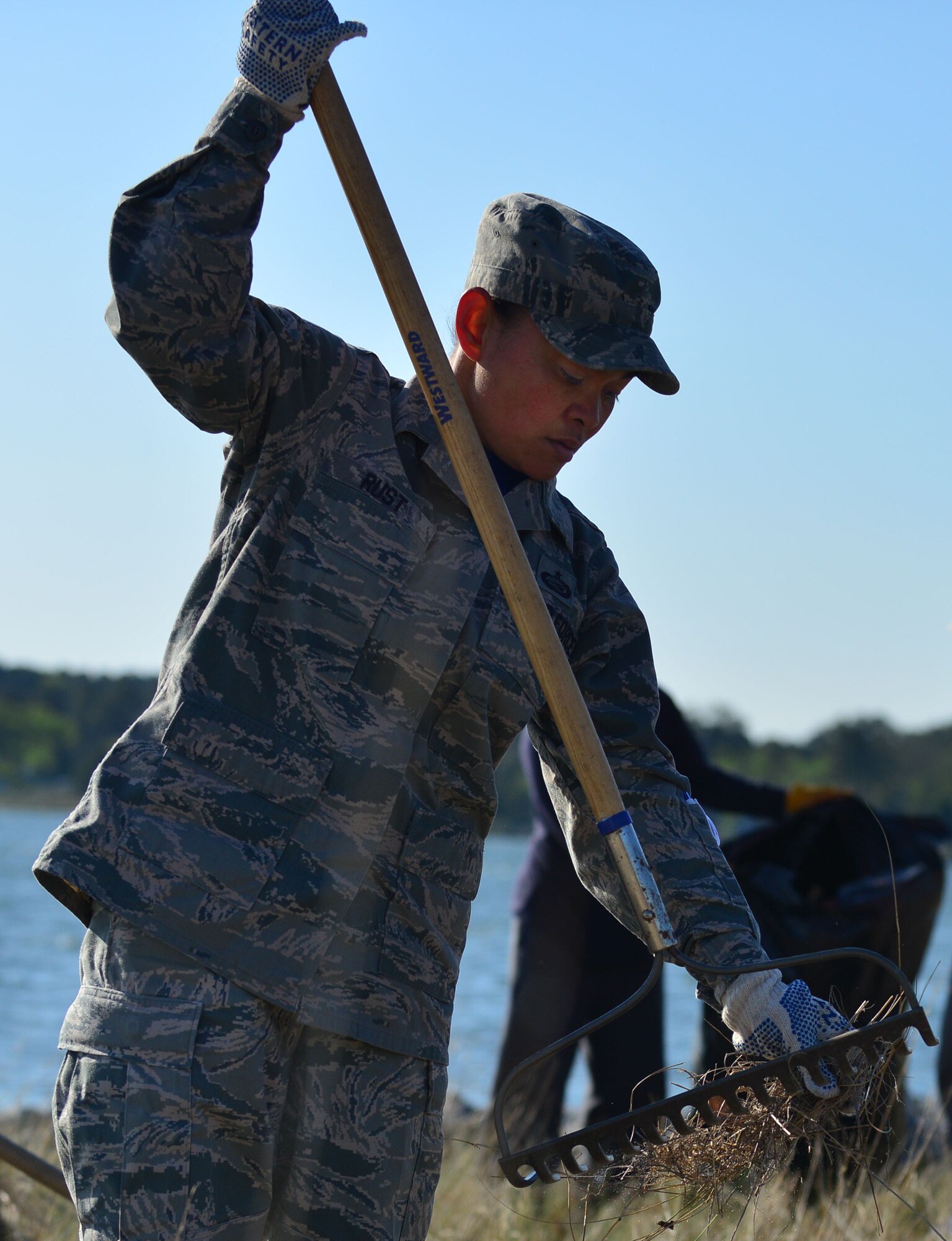 U.S. Air Force Tech. Sgt. Darlene Rust, 633rd Force Support Squadron force management noncommissioned officer-in-charge, cleans dead vegetation from the shoreline as part of Earth Week at Langley Air Force Base, Va., April 24, 2015. Joint Base Langley-Eustis Soldiers and Airmen took part in environmental conservation events throughout the week as stewards of the Hampton Roads area. (U.S. Air Force photo by Staff Sgt. Natasha Stannard/Released)