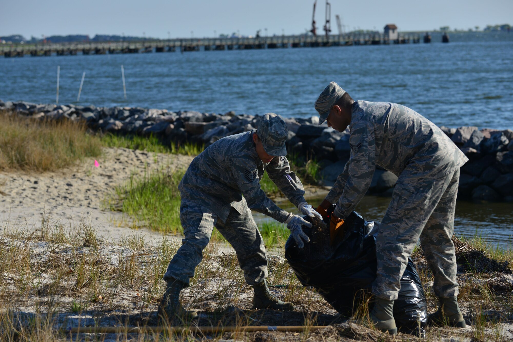 U.S. Air Force Tech. Sgt. Darlene Rust, 633rd Force Support Squadron force management noncommissioned officer-in-charge, left, and Airman 1st Class Walter Johnson, 633rd FSS force management personnelist, clean the shoreline as part of Earth Week at Langley Air Force Base, Va., April 24, 2015. Langley Airmen also cleaned the area of debris and dead vegetation to restore the area, and make room for marsh grass, which prevents erosion on the shoreline preserving inland habits of the area. (U.S. Air Force photo by Staff Sgt. Natasha Stannard/Released)