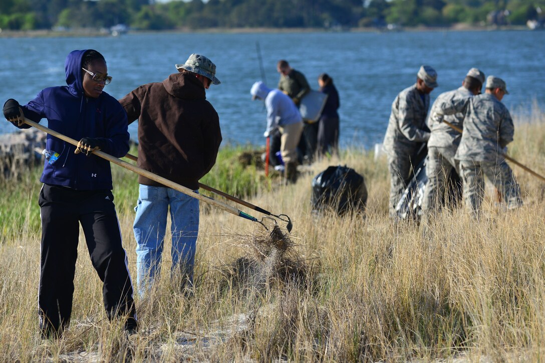 Joint Base Langley-Eustis Airmen clean the shoreline on base as the culminating event for Earth Week at Langley Air Force Base, Va., April 24, 2015. The Airmen cleaned the area of dead vegetation and debris, and planted grass that prevents erosion along the shore. (U.S. Air Force photo by Staff Sgt. Natasha Stannard/Released)