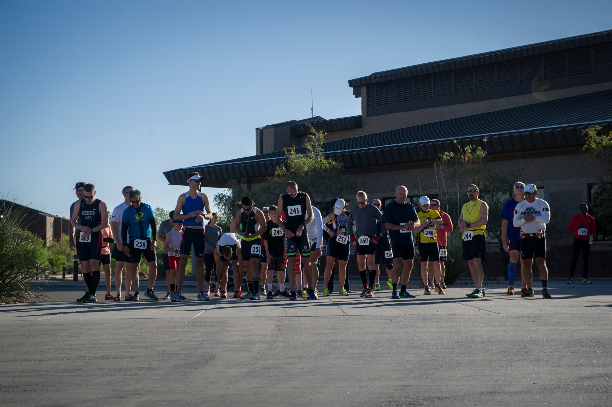 Runners gather at the starting line outside the Domenici Fitness Center on Holloman Air Force Base, N.M., before the start of the Joker Duathlon, April 25, 2015. This year’s event was a 5k run, 30k bike, and a final 3k run and was open to individual runners or two person teams.  (U.S. Air Force photo by Airman 1st Class Aaron Montoya / Released)