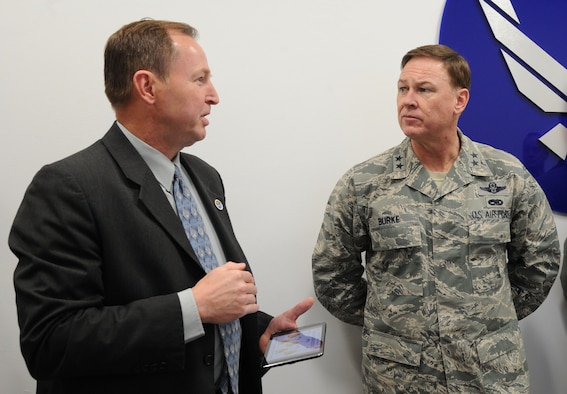 John Rogers explains the Shared Computing Environment to Air Force District of Washington Commander Maj. Gen. Darryl Burke at Joint Base Andrews, Md., April 24, 2015. The SCE architecture at Joint Base Andrews will reduce the hardware footprint and increase the support capacity to from 75,000 users to more than 200,000 users along the Eastern United States. Rogers is the 844th Communications Group chief technology officer. (U.S. Air Force photo/Master Sgt. Tammie Moore)
