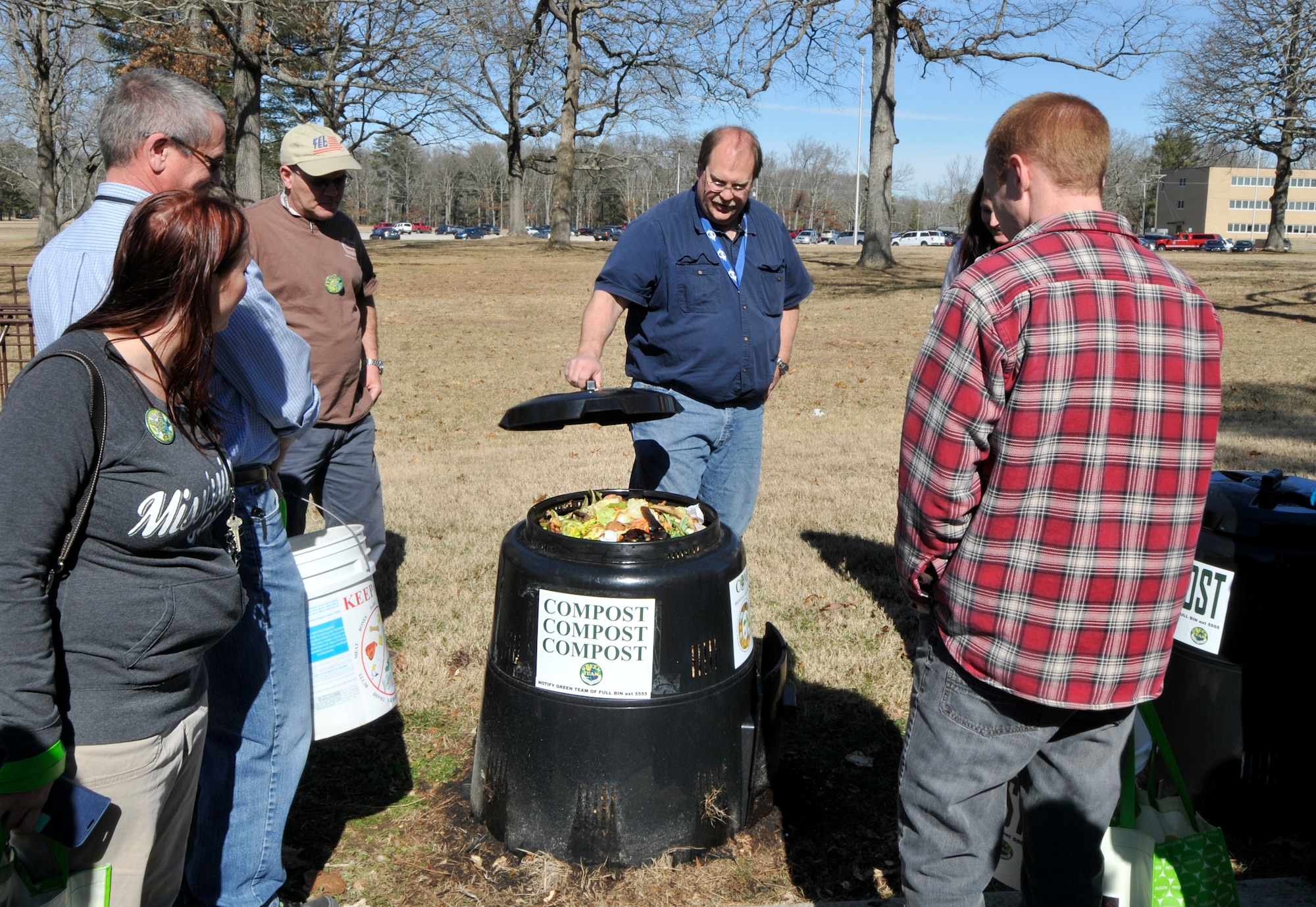 AEDC employee Kraig Smith (center) demonstrates the use of the new Earth Machine compost bins to the Compost at AEDC program volunteers. Funded by an Air Force Innovation Grant, the natural decomposition compost program helps AEDC personnel reduce the amount of compostable items delivered to the landfill from AEDC. (Photo by Jacqueline Cowan)
