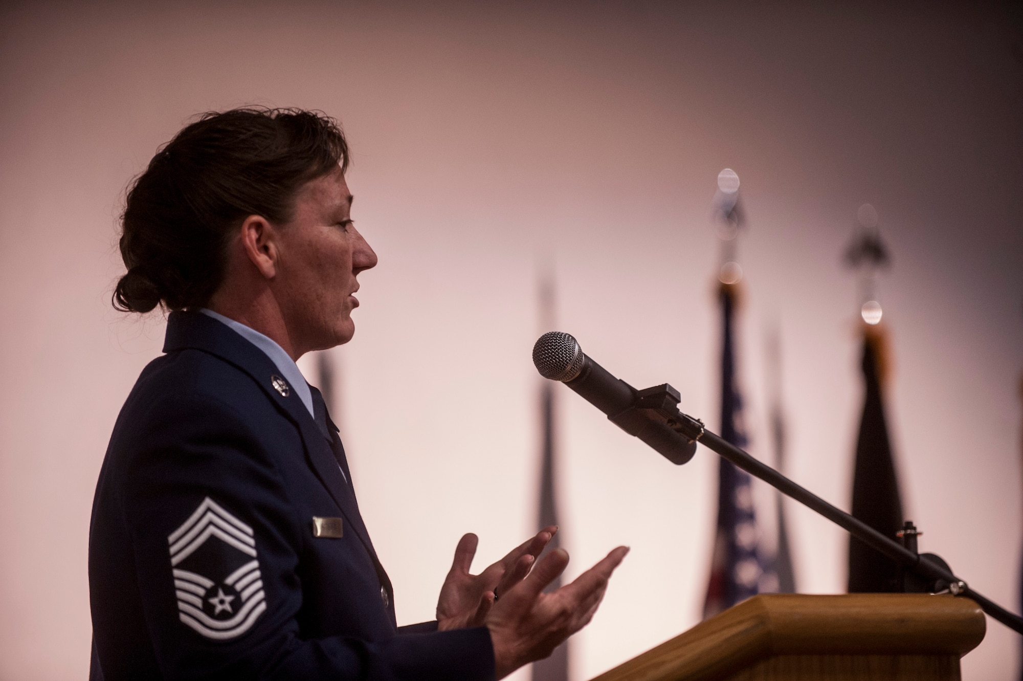 U.S. Air Force Chief Master Sgt. Diane Hansen, 52nd Aircraft Maintenance Squadron superintendent and guest speaker for the Community College of the Air Force graduation ceremony, speaks during the event at the base theater April 24, 2015, at Spangdahlem Air Base, Germany. During her speech Hansen stressed to the graduates the importance of helping their fellow Airmen achieve their educational goals. (U.S. Air Force photo by Senior Airman Rusty Frank/Released)