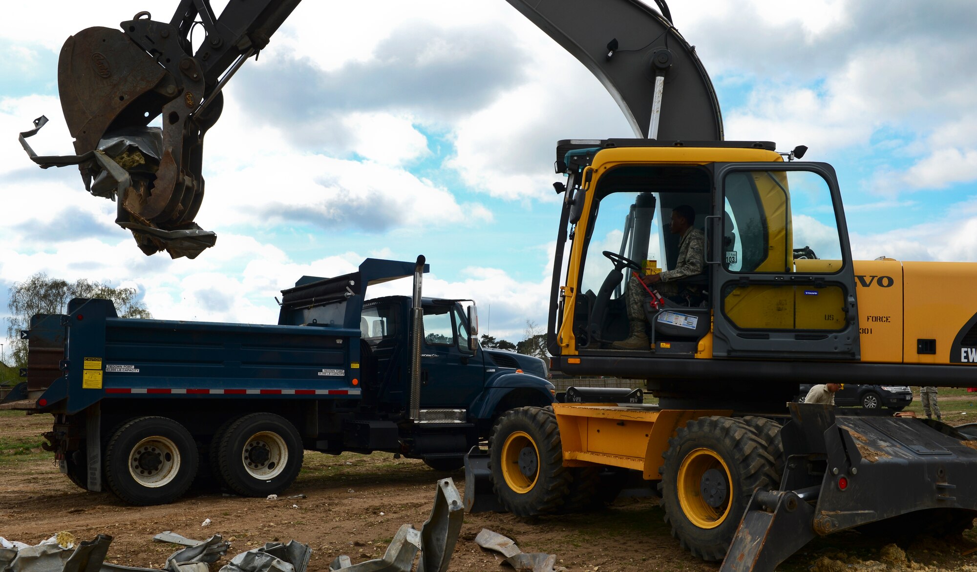 A 48th Civil Engineer Squadron heavy equipment operator transfers metal onto a truck to be recycled at Royal Air Force Lakenheath, England, April 22, 2015. Squadron Airmen recycled nearly six tons of metal from the site. (U.S. Air Force photo by Airman 1st Class Dawn M. Weber/Released)