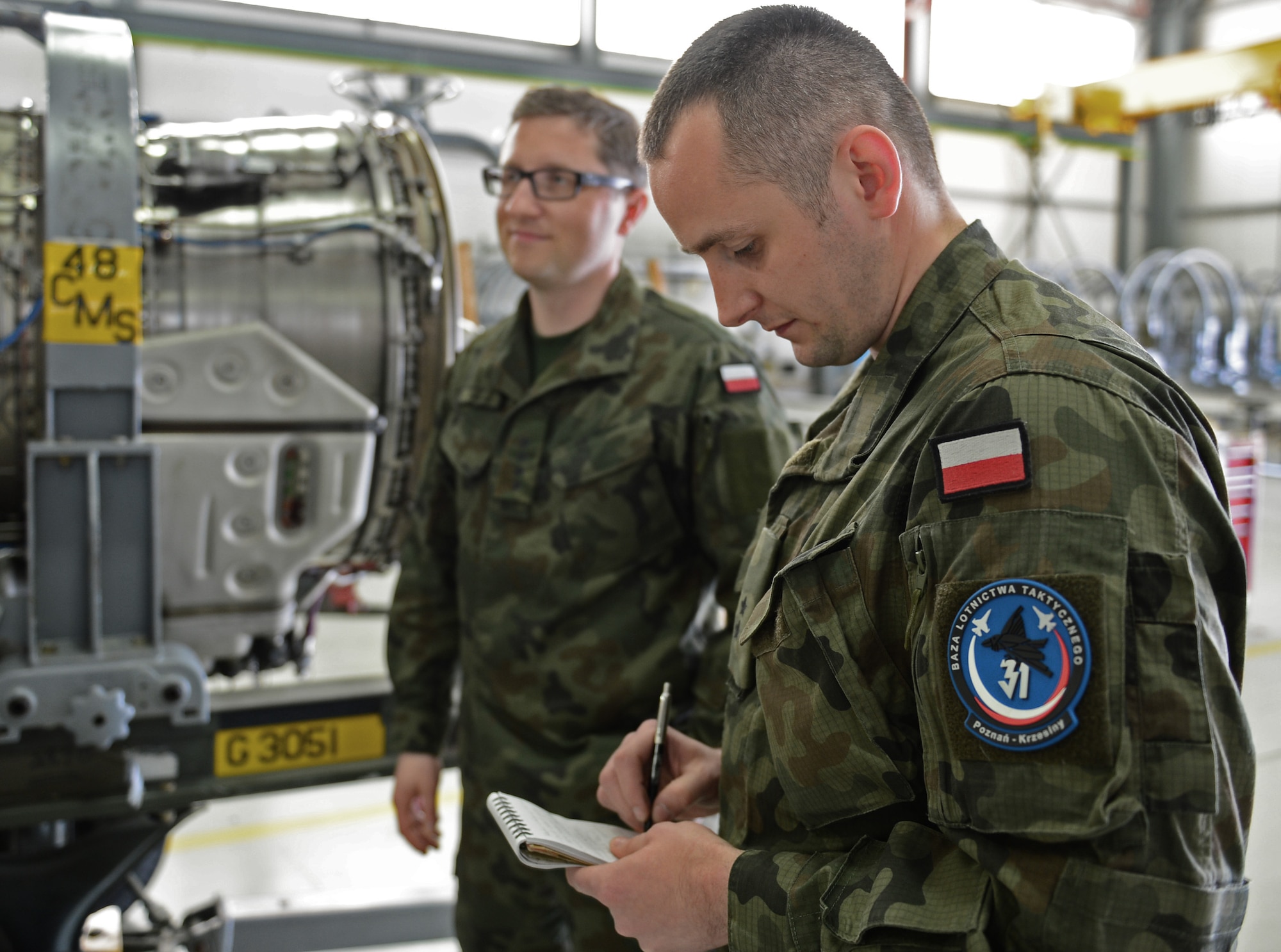 Polish air force 2nd Lt. Michal Miller, 31st Air Base propulsion section chief, takes notes on engine repair processes at Royal Air Force Lakenheath, England, April 23, 2015. The Polish airmen visited from Poznan-Krzesiny Air Base to learn how the Liberty Wing operates and manages an engine overhaul facility. (U.S. Air Force photo by Airman 1st Class Erin R. Babis/Released)
