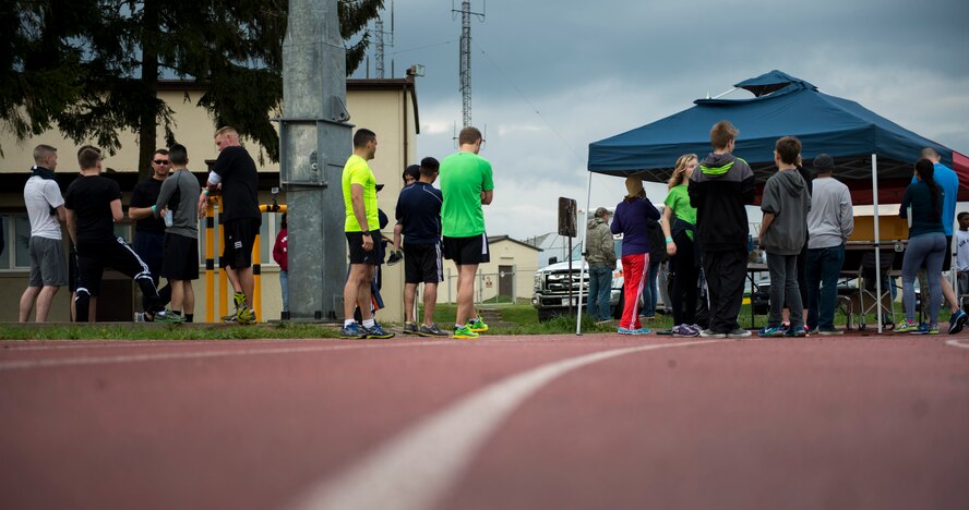 Participants of the Bitburg Middle High School Junior Reserve Officer Training Corps 5K run stand alongside the outdoor track at Spangdahlem Air Base, Germany, April 25, 2015. Nearly 30 participants competed in the event celebrating the 99th anniversary of JROTC. (U.S. Air Force photo by Airman 1st Class Luke Kitterman/Released)