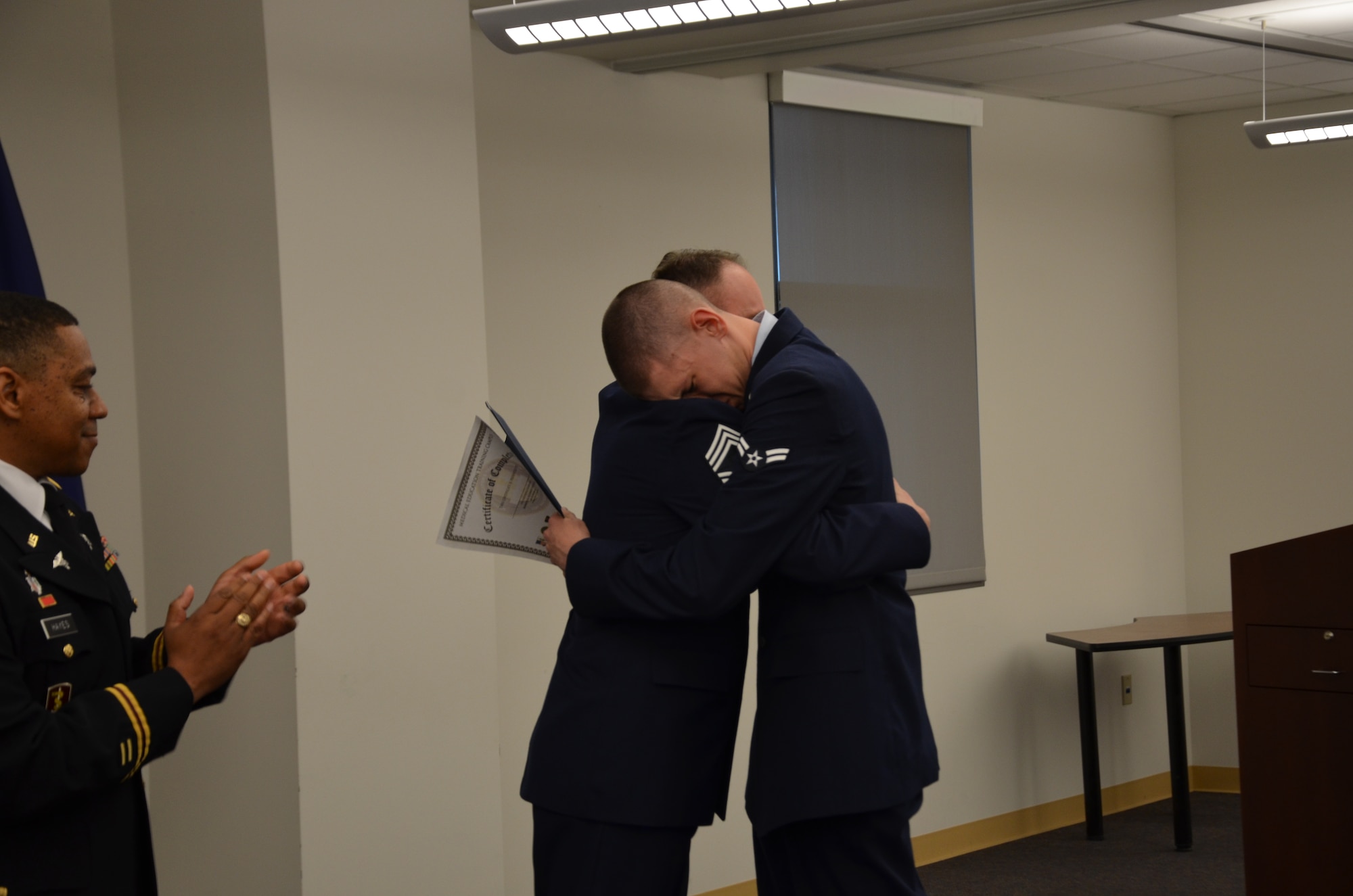Airman Christian Frizzell, a Biomedical Equipment Technician (BMET) student at the Medical Education and Training Campus, hugs his father, Chief Master Sgt. Charles Frizzell after his dad presents him with his graduation certificate during his class graduation ceremony April 10. Airman Frizzell is starting his new career at Wright-Patterson Air Force Base, Ohio. His father, also a BMET, is currently assigned as the senior enlisted advisor to the commander at the 374th Medical Group at Yokota Air
Base, Japan. (Photo by Lisa Braun)
