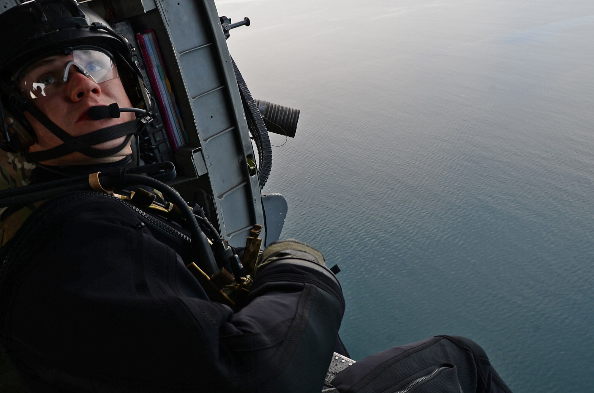 A pararescueman assigned to the 57th Rescue Squadron flies on an HH-60G Pave Hawk helicopter during exercise Joint Warrior 15-1 in Scotland, April 22, 2015. Pararescuemen train often using real-world scenarios in order to enhance their capabilities and prepare for worldwide personnel recoveries. (U.S. Air Force photo by Senior Airman Erin O'Shea/Released) 