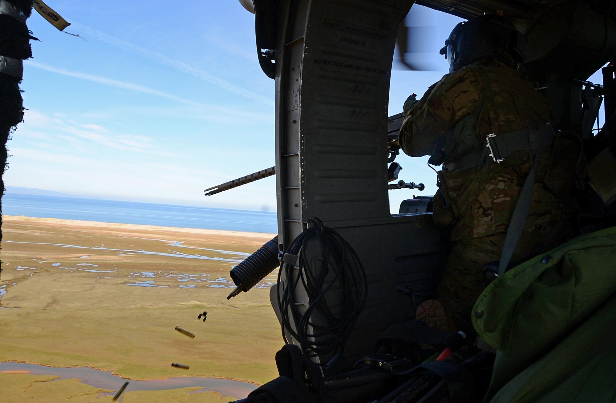 A special missions aviator assigned to Royal Air Force Lakenheath's 56th Rescue Squadron fires a .50-caliber machine gun out of an HH-60G Pave Hawk helicopter during exercise Joint Warrior 15-1 in Scotland, April 22, 2015. Airmen assigned to the 56th and 57th Rescue Squadrons participated in the multinational exercise to increase their readiness capabilities. (U.S. Air Force photo by Senior Airman Erin O'Shea/Released) 