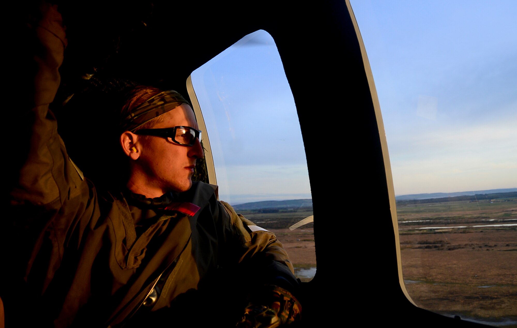 A pararescueman assigned to Royal Air Force Lakenheath's 57th Rescue Squadron, peers out the window of an HH-60G Pave Hawk helicopter during exercise Joint Warrior 15-1 in Scotland, April 22, 2015. The exercise tested the ability of armed forces from 14 countries to synchronize during worldwide operations. (U.S. Air Force photo by Senior Airman Erin O'Shea/Released)