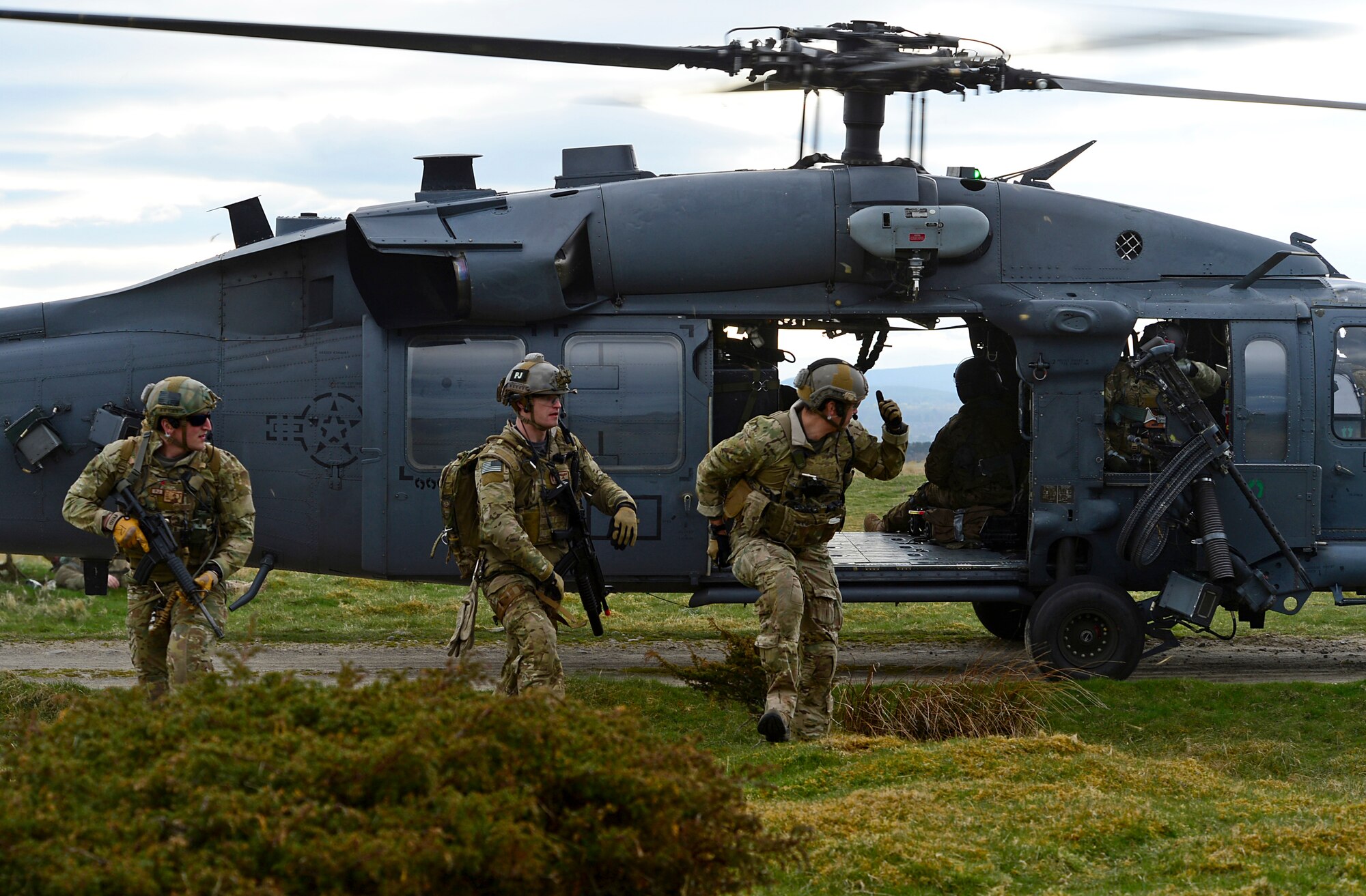 Pararescuemen assigned to Royal Air Forces Lakenheath's 57th Rescue Squadron depart an HH-60G Pave Hawk during the Joint Warrior 15-1 training exercise in Scotland, April 21, 2015. Joint Warrior provided unique training the pararescuemen could expect to encounter during real-world scenarios. (U.S. Air Force photo by Senior Airman Erin O'Shea/Released)