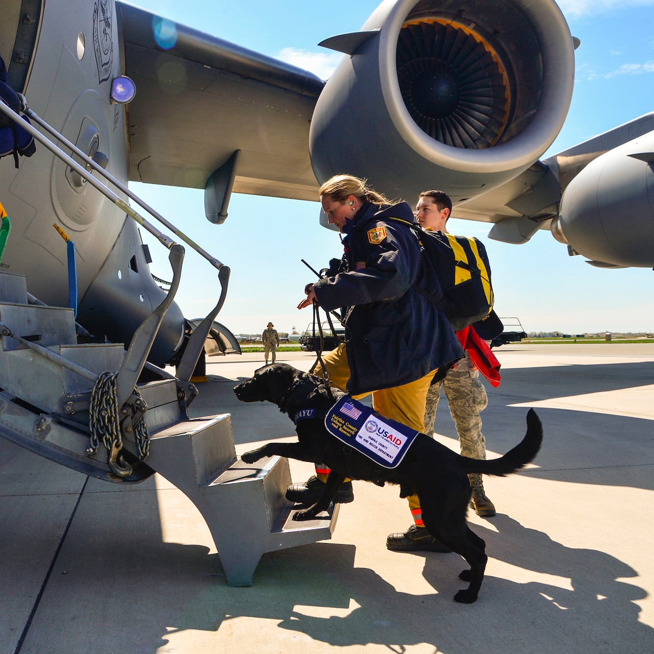 Jennifer Massey and her K-9 dog, Phayu, board a U.S. Air Force C-17 Globemaster III on Dover Air Force Base, Del., April 26, 2015, bound for Nepal. Massey is a Fairfax County Urban Search and Rescue K-9 search specialist from Fairfax, Va., serving as part of a 69-person search and rescue team deploying to Nepal to assist in rescue operations after the country was struck by a 7.8-magnitude earthquake. U.S. Air Force photo by Airman 1st Class William Johnson