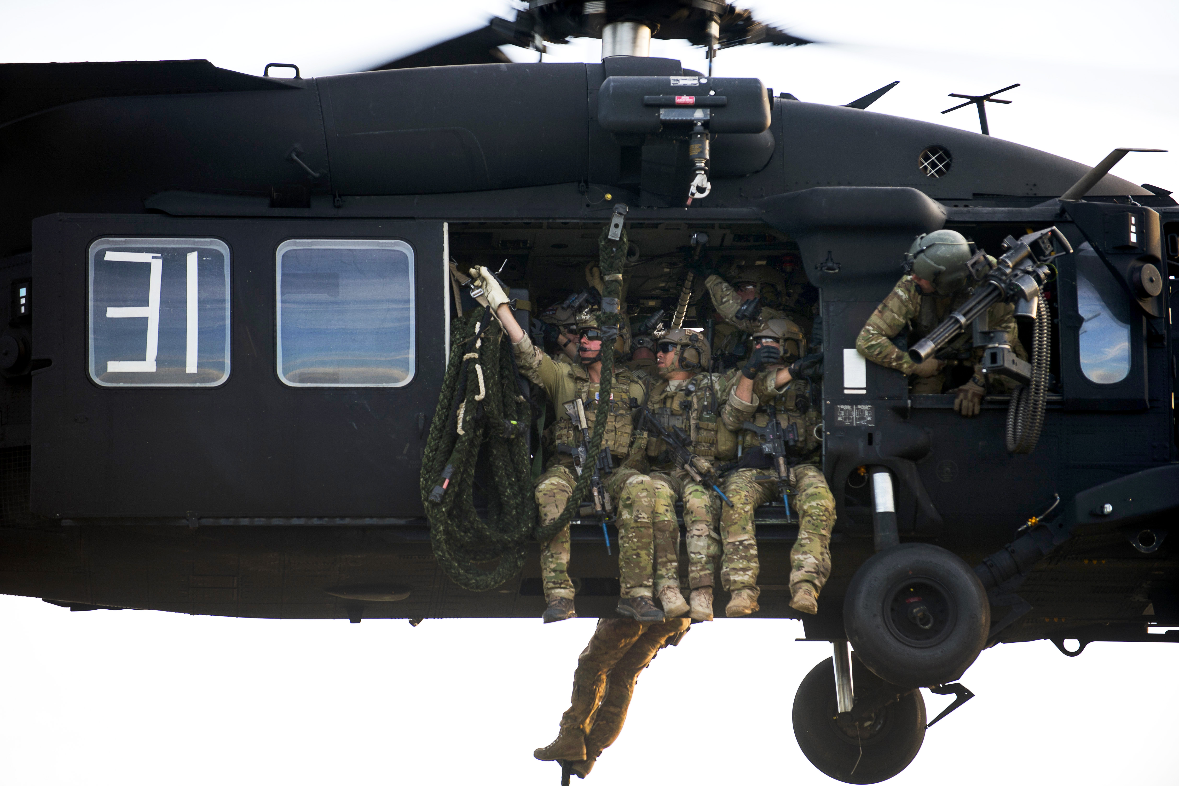 U.S. Special Forces soldiers prepare to fast-rope out of a UH-60