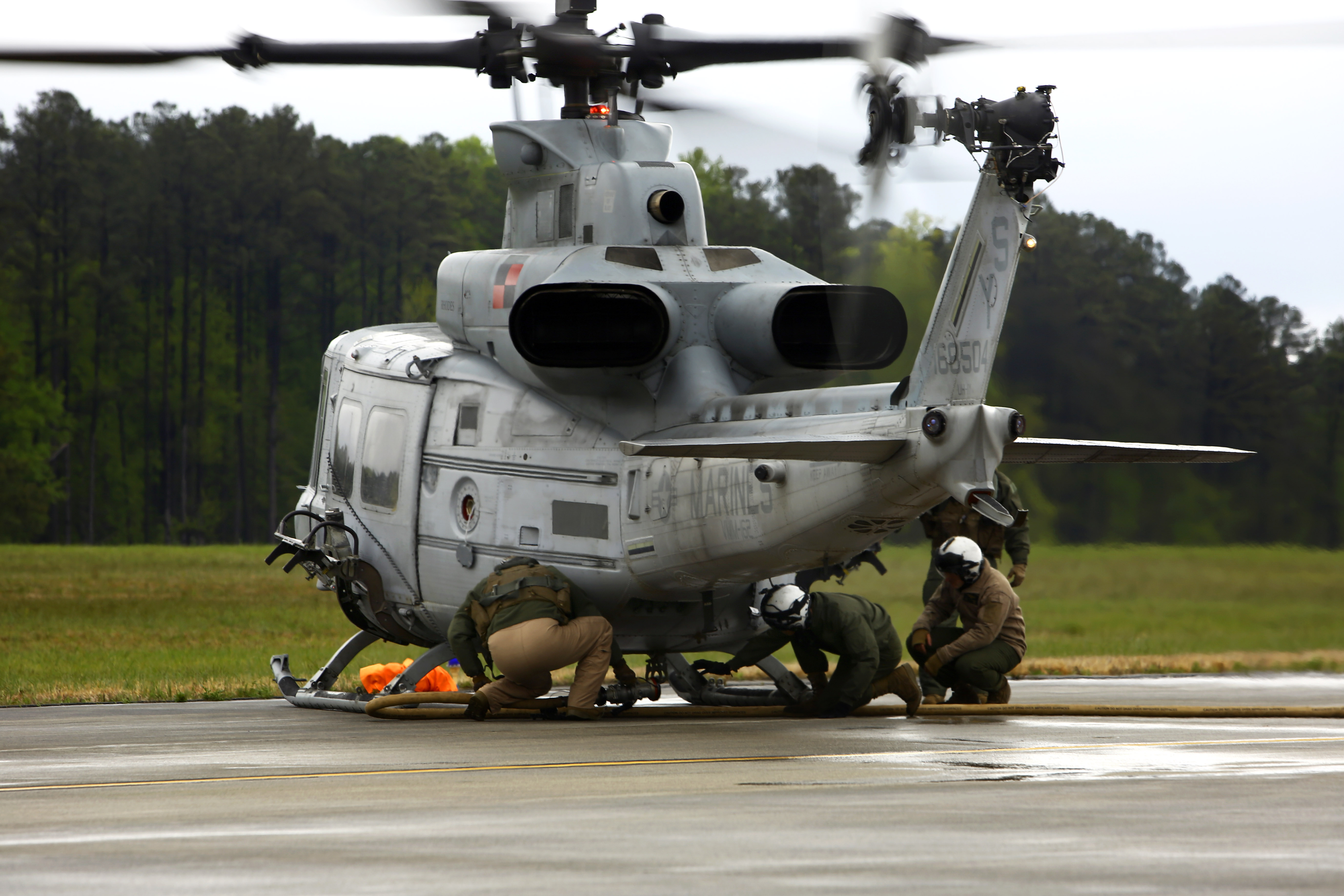 U.S. Marines remove the fuel hose from an UH-1Y Venom helicopter as ...