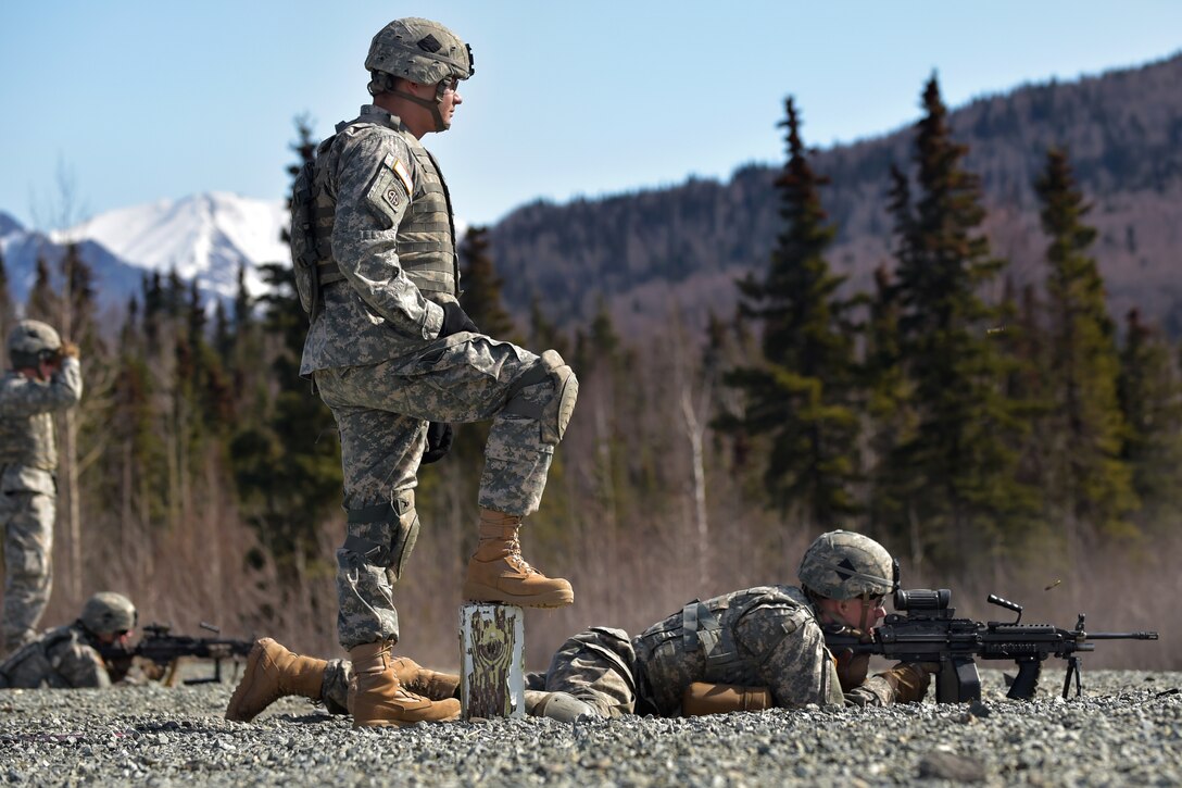 Army Sgt. Dusty Peevey, left, watches Army Pvt. Garrett Evans fire an M249 squad automatic weapon at Grezelka range on Joint Base Elmendorf-Richardson, Alaska, April 23, 2015. Peevey and Evans are assigned to the 25th Infantry Division's Company C, 1st Battalion, 501st Infantry Regiment, 4th Infantry Brigade Combat Team Airborne, Alaska.