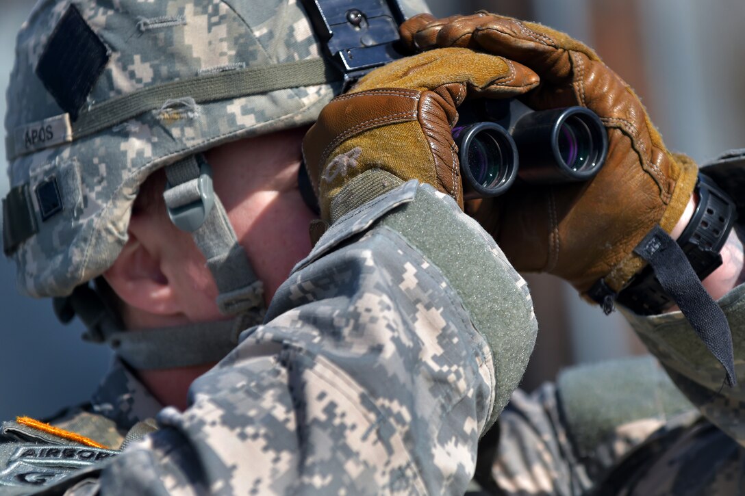 Army Staff Sgt. James Waterman uses binoculars to monitor the accuracy of his soldiers firing M249 squad automatic weapons at Grezelka range on Joint Base Elmendorf-Richardson, Alaska, April 23, 2015. Waterman is assigned to the 25th Infantry Division's Company C, 1st Battalion, 501st Infantry Regiment, 4th Infantry Brigade Combat Team Airborne, Alaska.