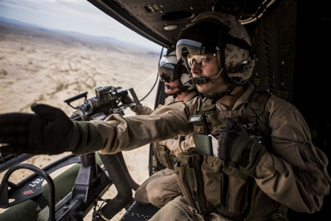 Marine Corps Sgt. David J. Herwig identifies a target for Cpl. Kyle J. Mohr during Final Exercise 3 as part of Weapons and Tactics Instructor Course 2-15 near Yuma, Ariz., April 25, 2015. Herwig is a crew chief assigned to Marine Light Attack Helicopter Squadron 267.