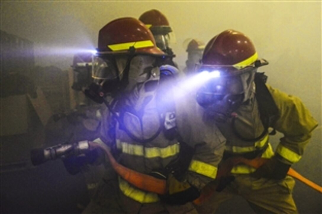 U.S. Navy sailors fight a simulated fire in the hangar bay during an survivability exercise aboard the aircraft carrier USS John C. Stennis in the Pacific Ocean, April 23, 2015. The exercise assesses the ship's abilities to conduct combat missions, support functions and survive complex casualty control situations.  