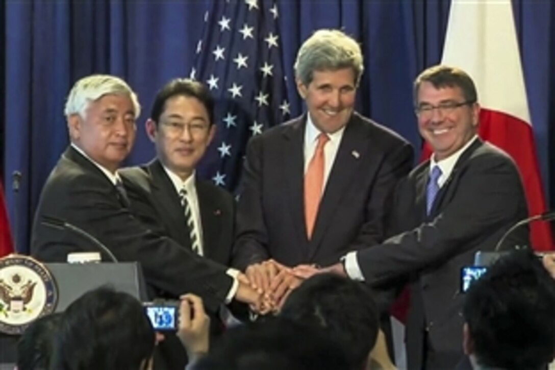 U.S. Defense Secretary Ash Carter, far right, and U.S. Secretary of State John F. Kerry, second from right, shake hands with Japanese Defense Minister Gen Nakatani, far left, and Japanese Foreign Minister Fumio Kishida after a joint press conference in New York City, April 27, 2015.