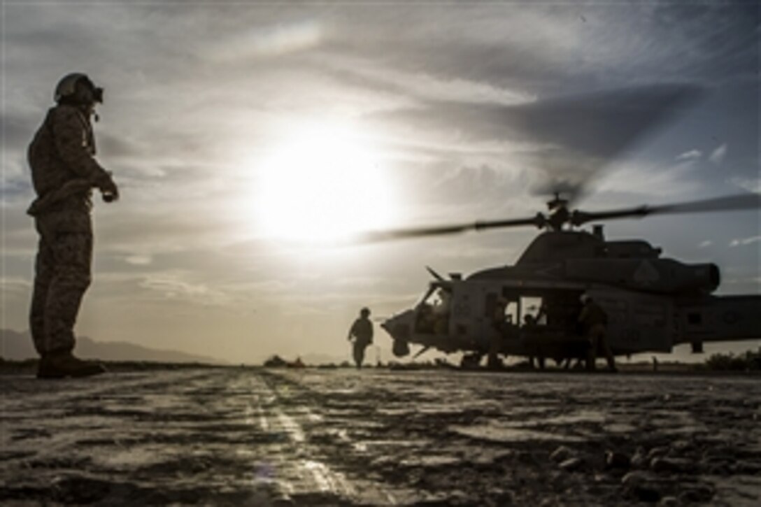 A Marine watches as fellow Marines refuel a UH-1Y Venom helicopter at the end of a final exercise during Weapons and Tactics Instructor Course 2-15 near Yuma, Ariz., April 25, 2015.