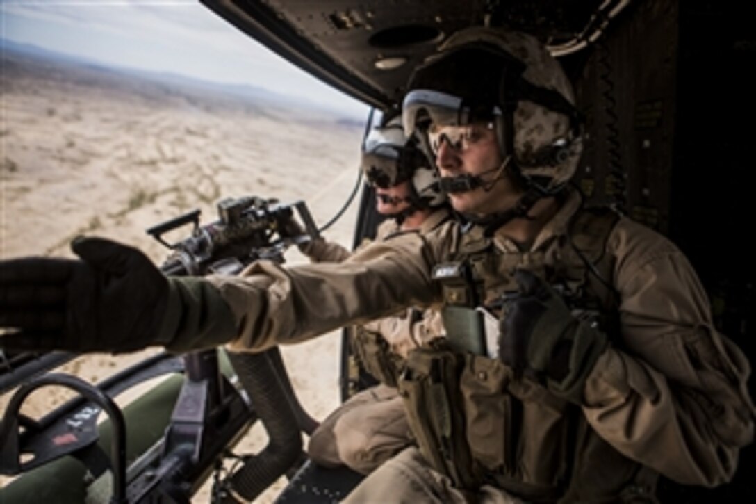 Marine Corps Sgt. David J. Herwig identifies a target for Cpl. Kyle J. Mohr during Final Exercise 3 as part of Weapons and Tactics Instructor Course 2-15 near Yuma, Ariz., April 25, 2015. Herwig is a crew chief assigned to Marine Light Attack Helicopter Squadron 267.