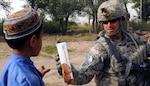 U.S. Army Sgt. Joshua Nadeau, an infantryman from Brattleboro, Vt., with Delta Company, 3rd Battalion, 172nd Infantry Regiment of the Vermont National Guard gives snacks to a child during a patrol in Rahman Kheyl village Sept. 15, 2010.